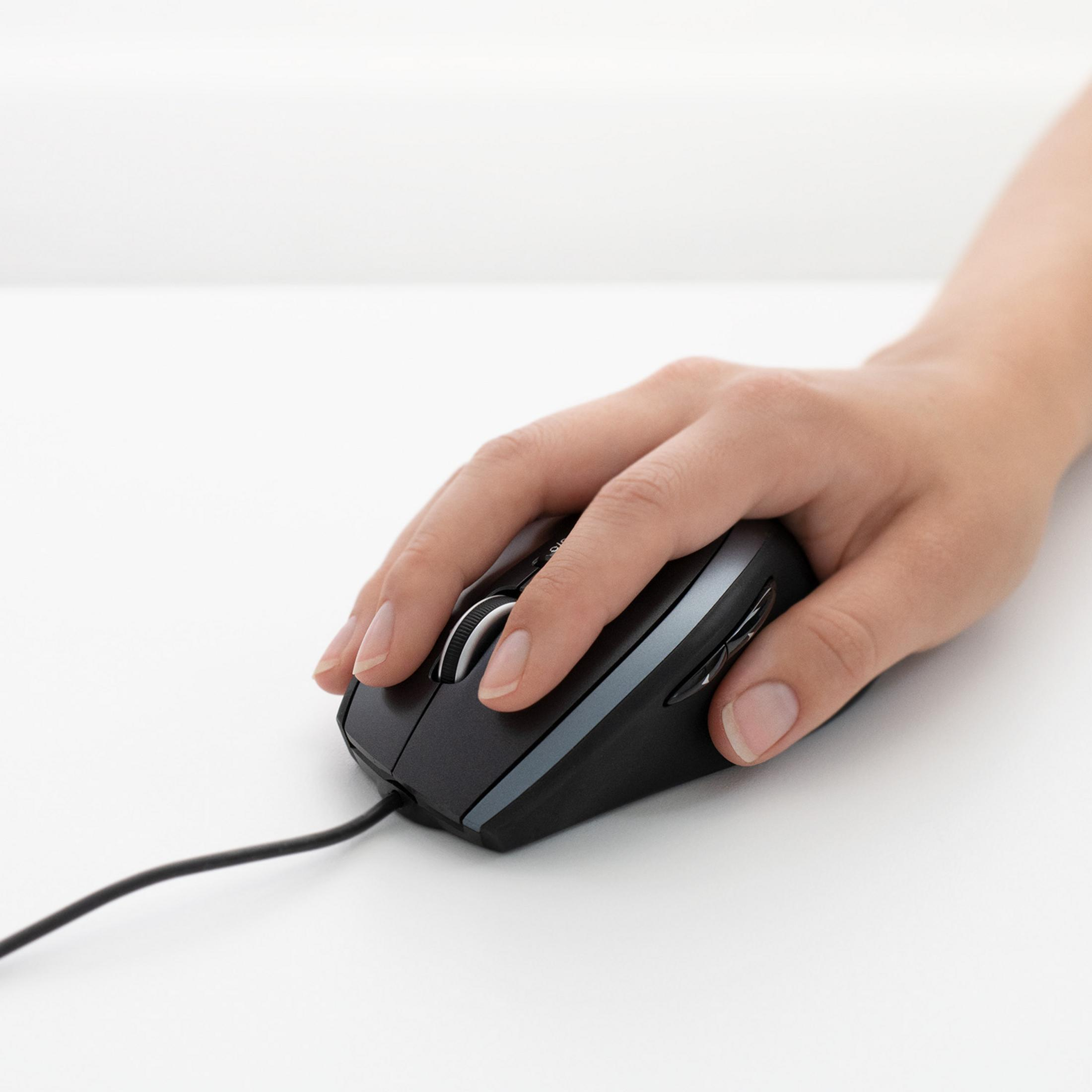 Eine Hand liegt auf einer schwarzen Computermaus auf einer weißen Oberfläche. Die Maus hat ein Scrollrad.