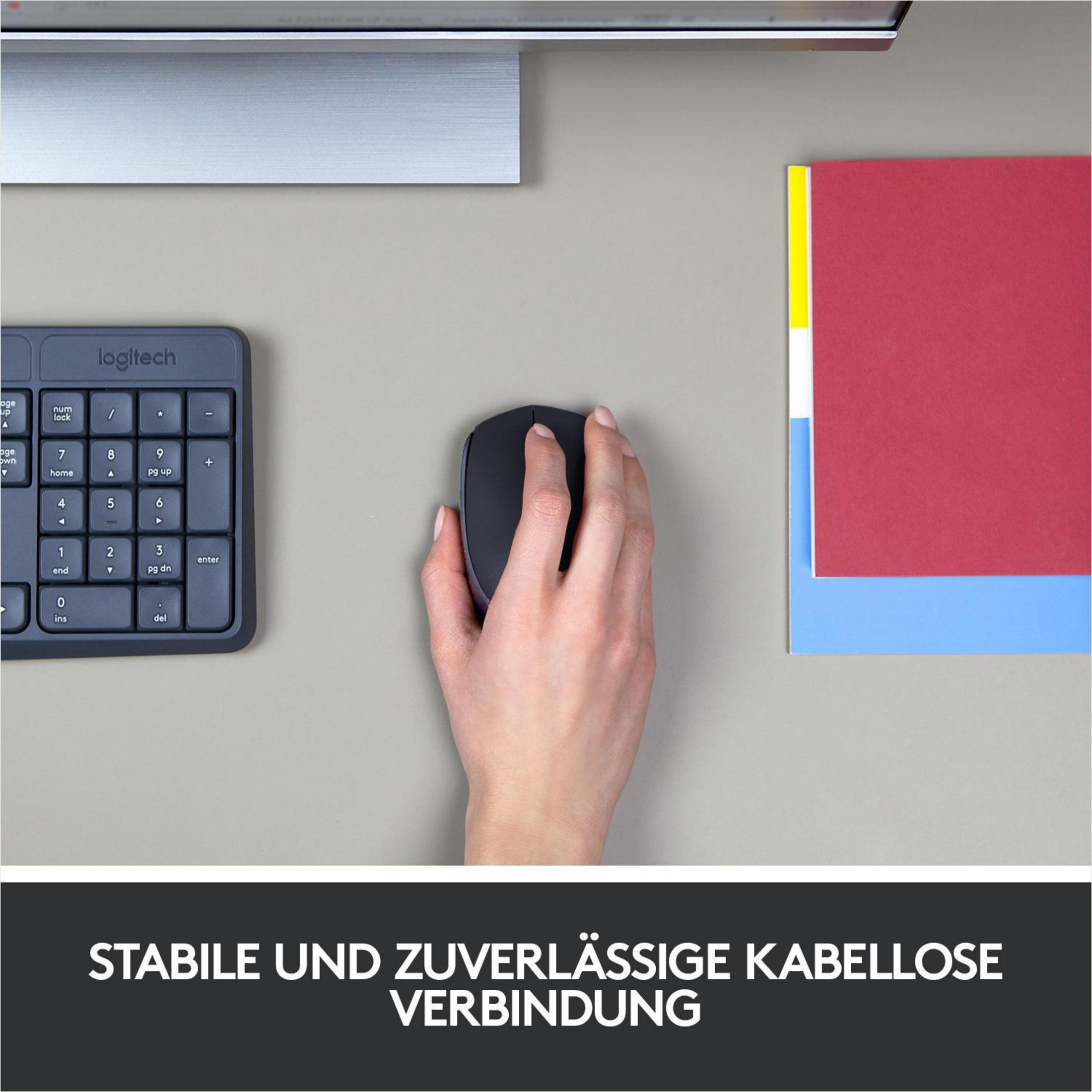 Dłoń używająca czarnej myszy na szarym biurku. Klawiatura i czerwono-żółty papier również widoczne.