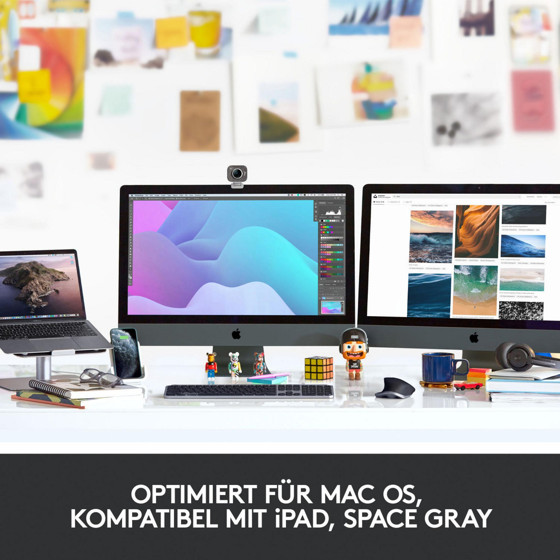 Configurazione scrivania con due monitor, laptop, periferiche e webcam.