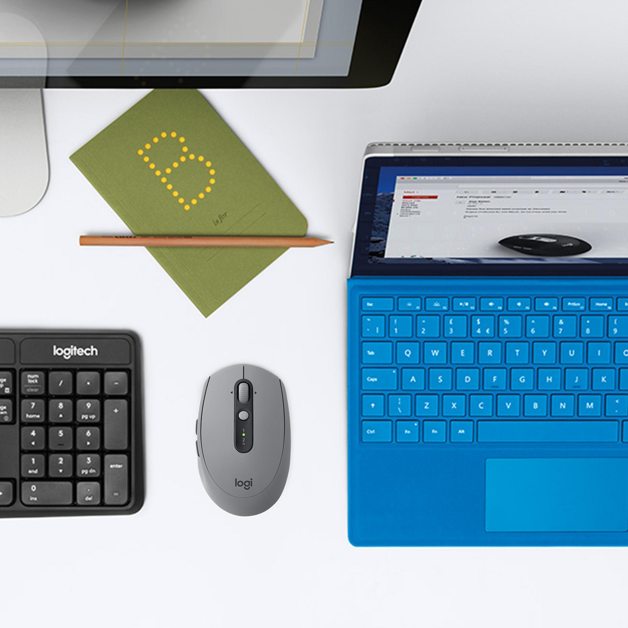 Miejsce pracy z laptopem, myszą, notatnikiem i klawiaturą numeryczną. Biała powierzchnia.