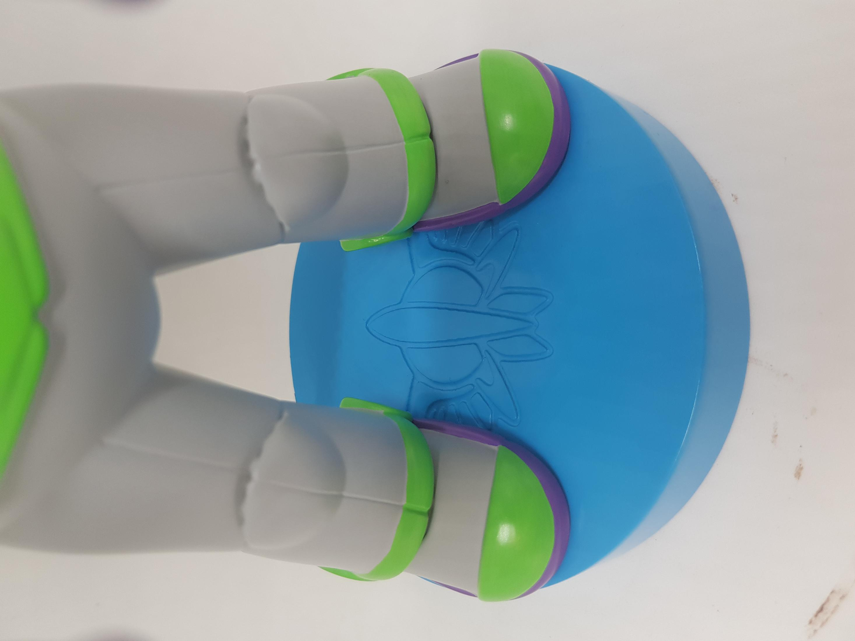 Piedi del giocattolo di Buzz Lightyear su un supporto blu, con un dettaglio di razzo.