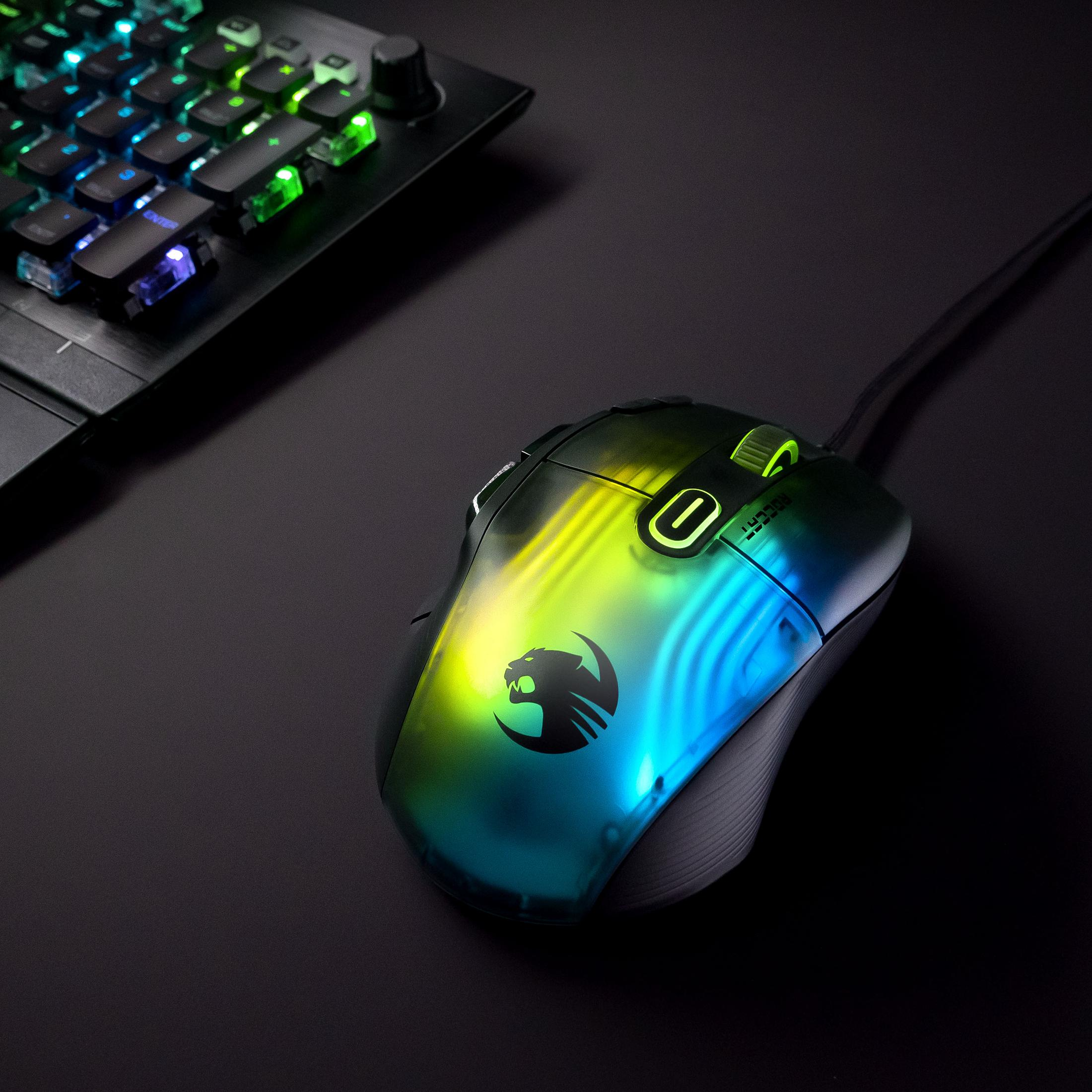 Mouse da gioco con illuminazione RGB. Il mouse ha un logo e si trova su una superficie nera con una tastiera.