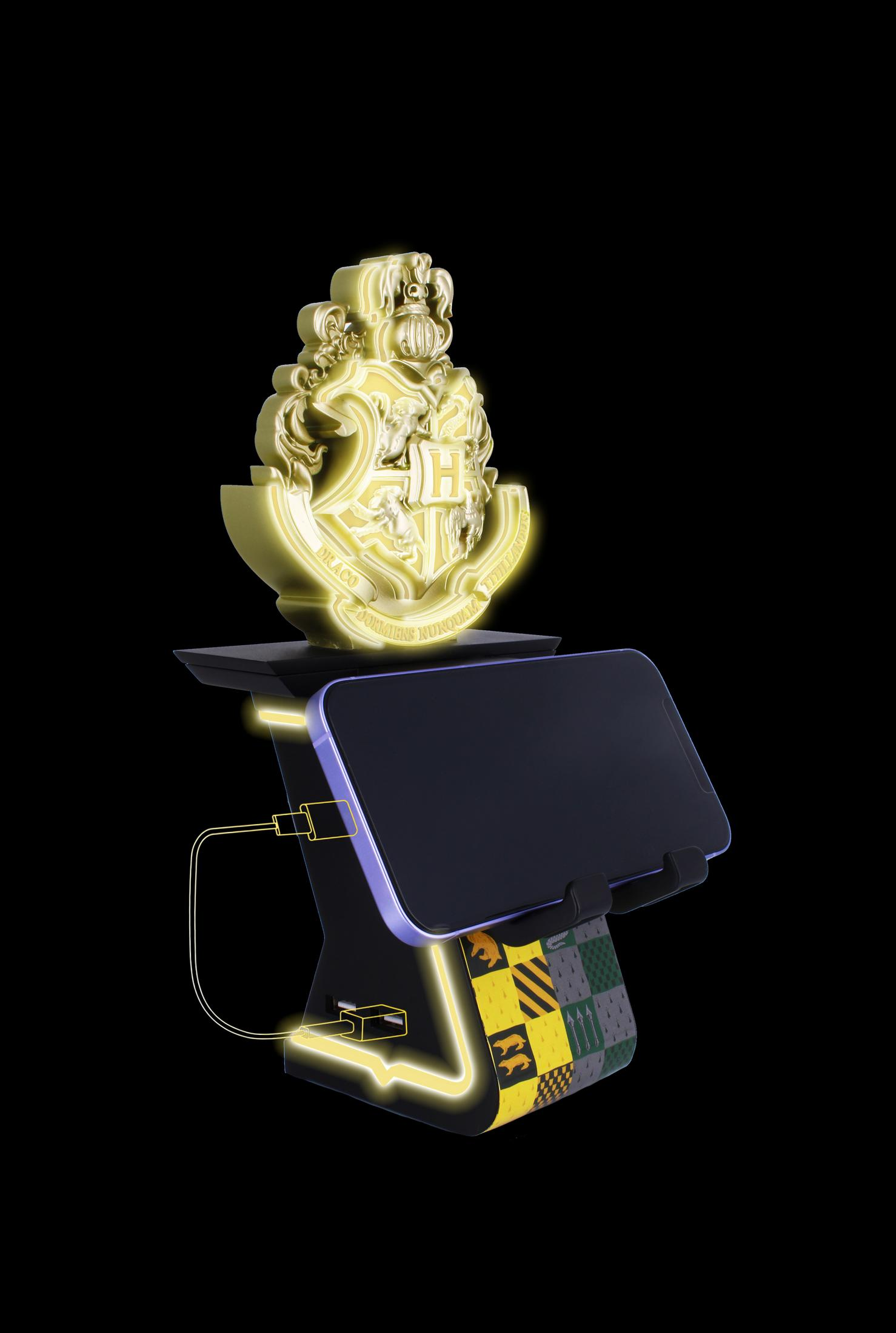 Stemma d'oro di Hogwarts, telefono su supporto, accenti luminosi e sfondo nero.