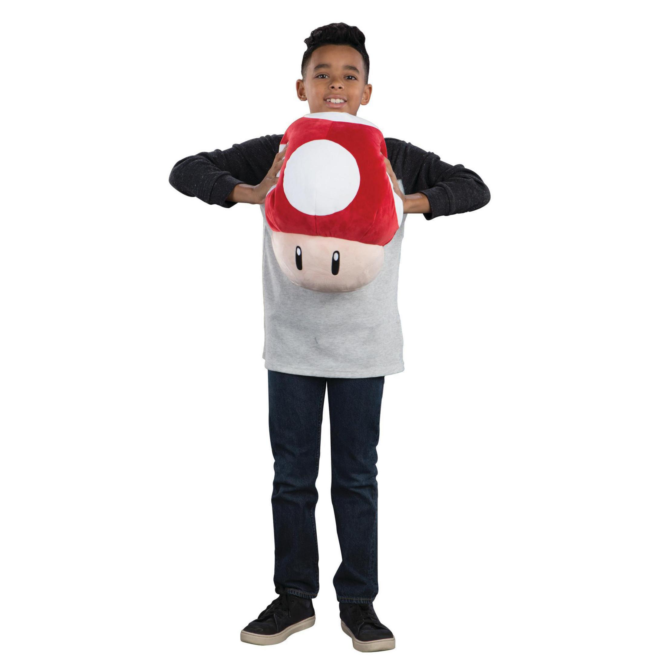 Ragazzo che tiene un peluche a forma di fungo rosso e bianco. Indossa una maglia grigia e jeans blu.