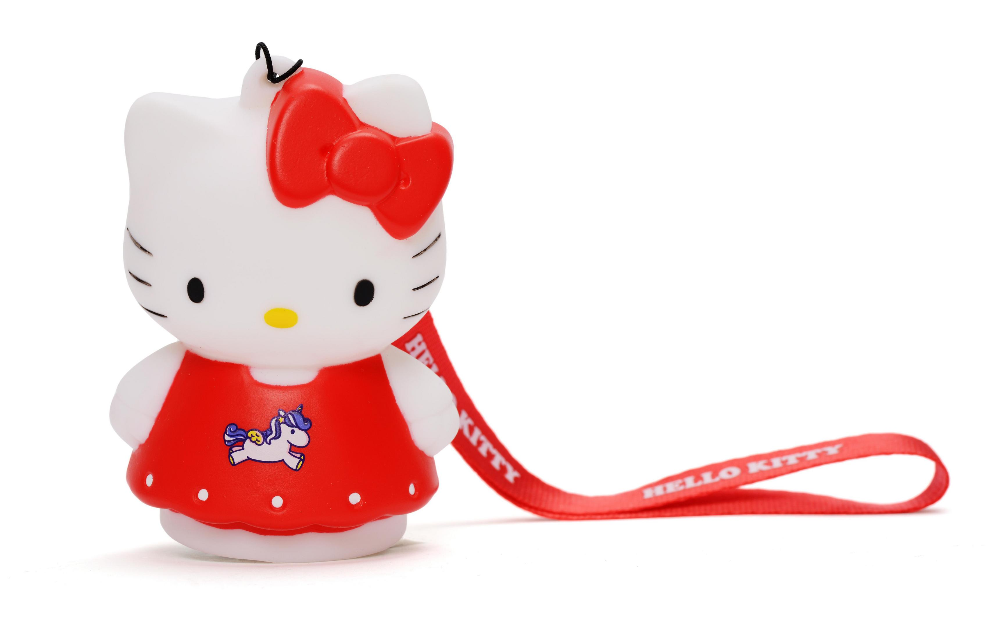Eine Hello Kitty-Figur in einem roten Kleid mit roter Schleife. Sie hat einen roten Riemen und einen weißen Hintergrund.