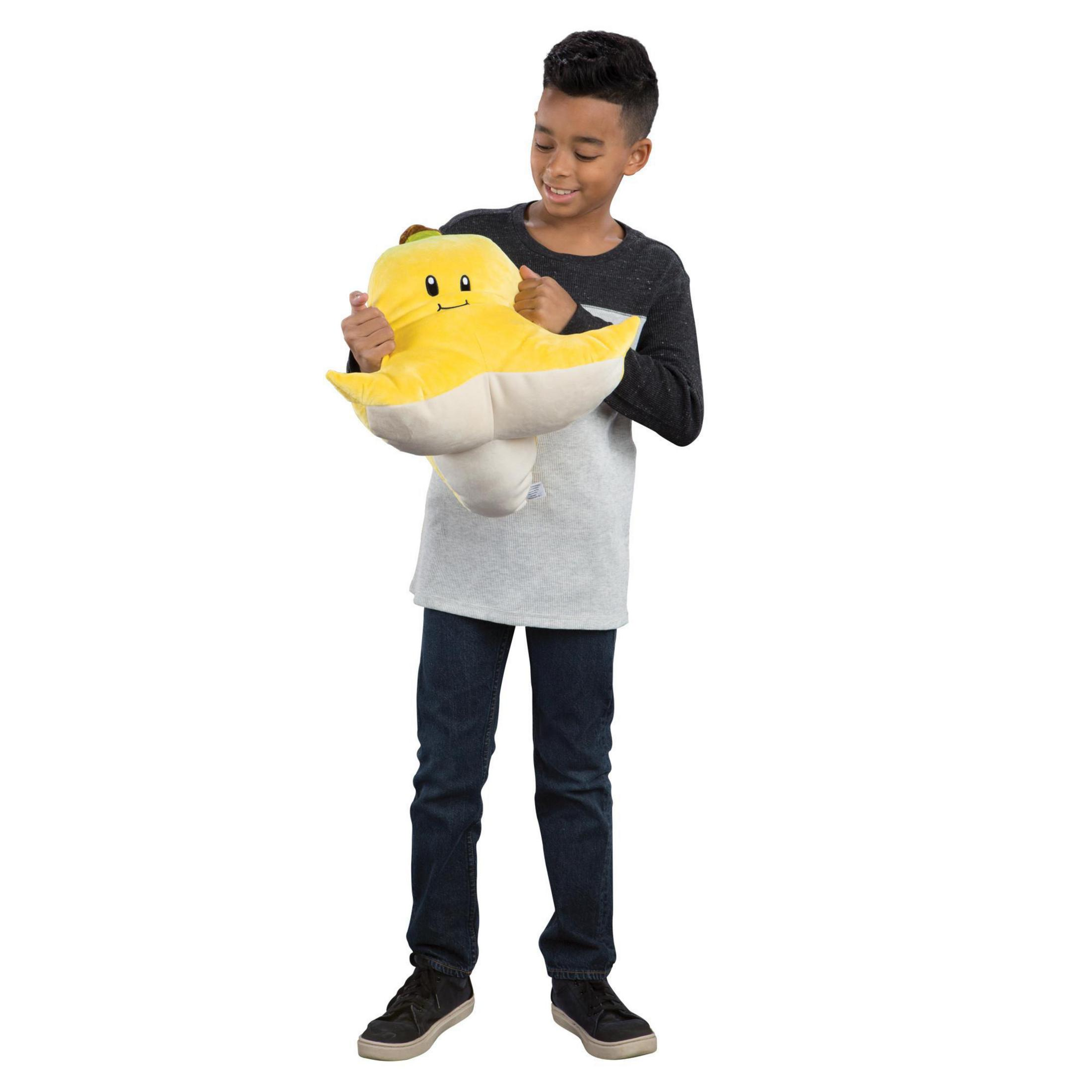 Garçon tenant une peluche jaune. Le jouet est une banane avec un visage.