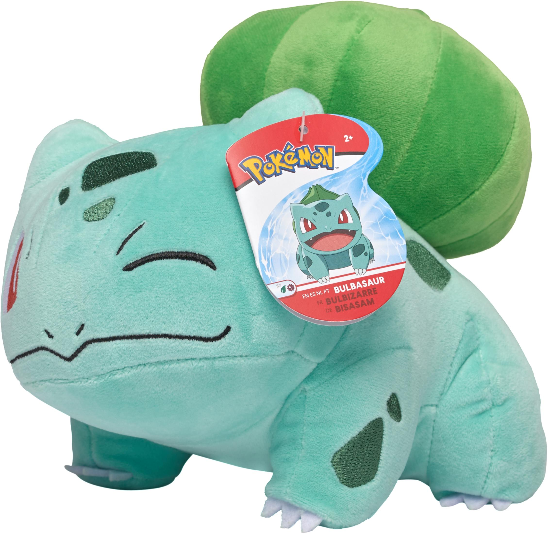Ein Bulbasaur-Plüschtier mit grünem Körper und Knolle auf dem Rücken, mit Pokémon-Anhänger.