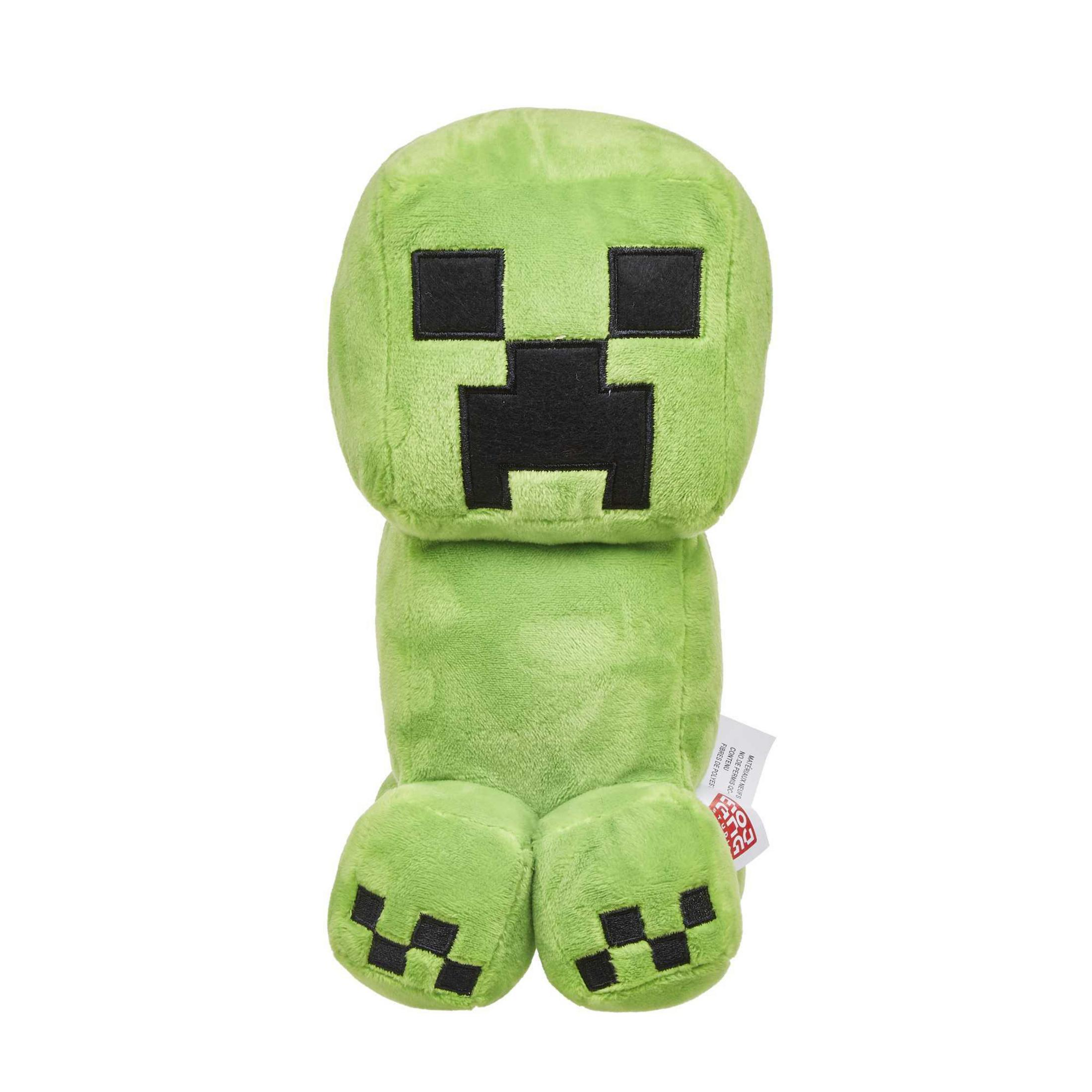 Ein grünes Minecraft Creeper Plüschtier, stehend auf weißem Untergrund, mit Etikett.