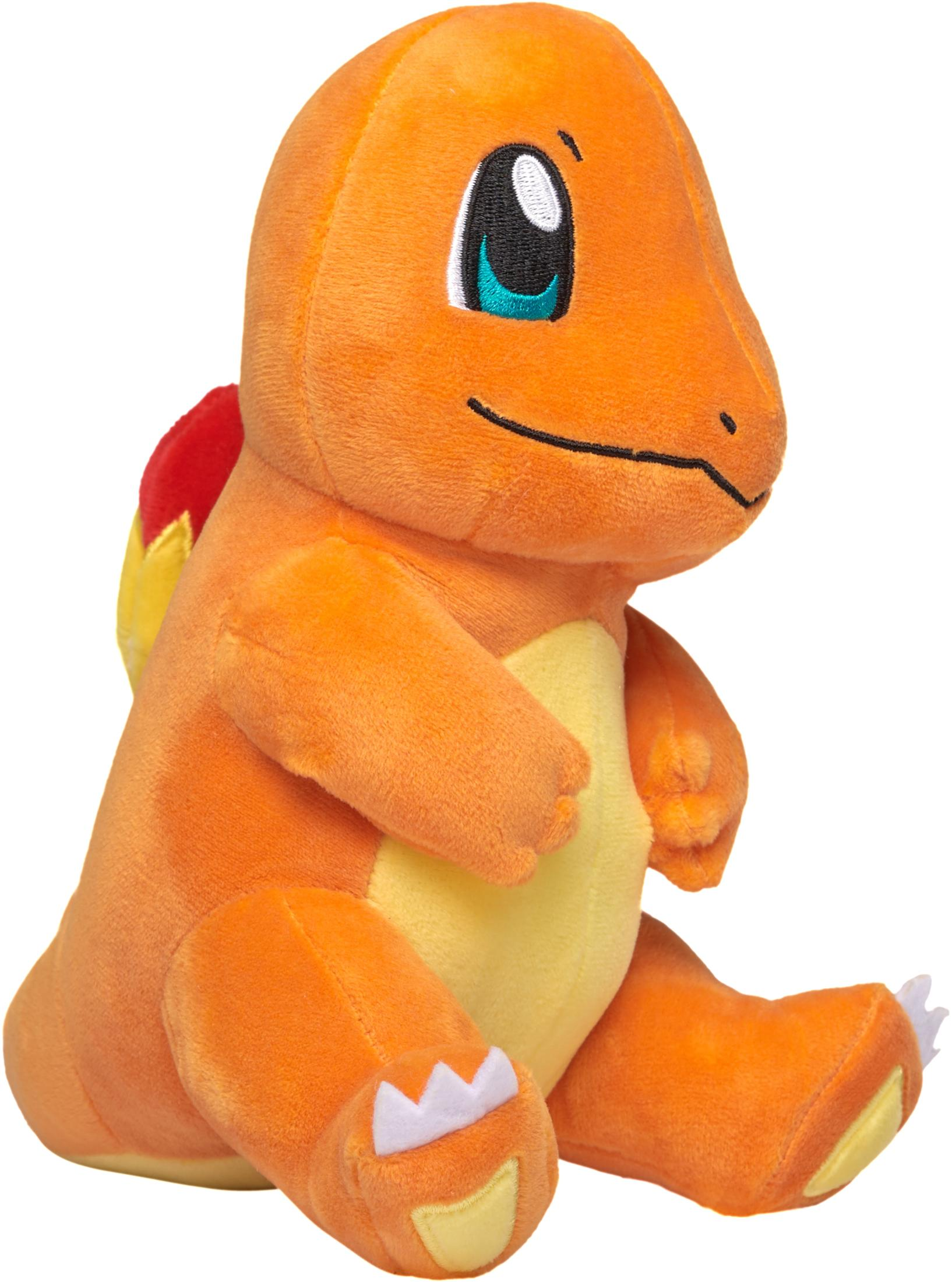 Ein orangefarbenes Charmander-Plüschtier sitzt und schaut nach vorne. Hat weiße Krallen und eine rote und gelbe Flamme.