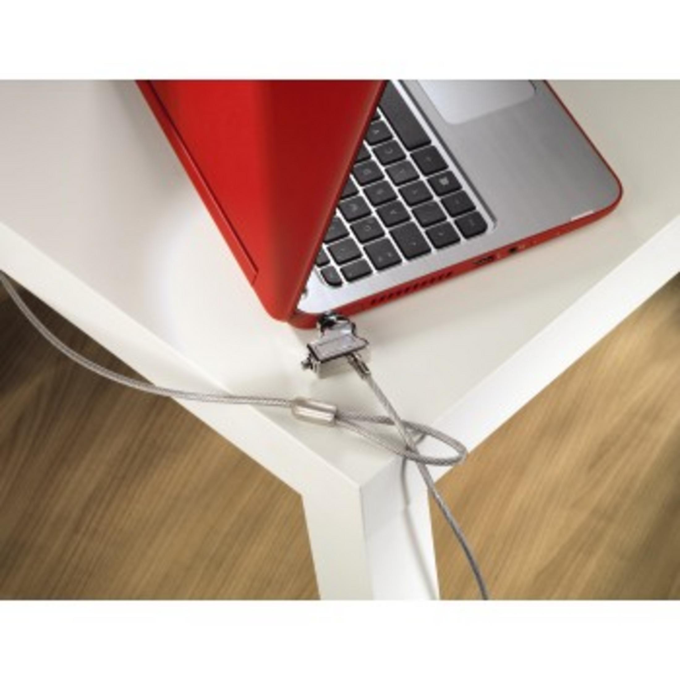 Laptop mit Kabelschloss an einem weißen Tisch gesichert. Roter Laptop-Deckel.