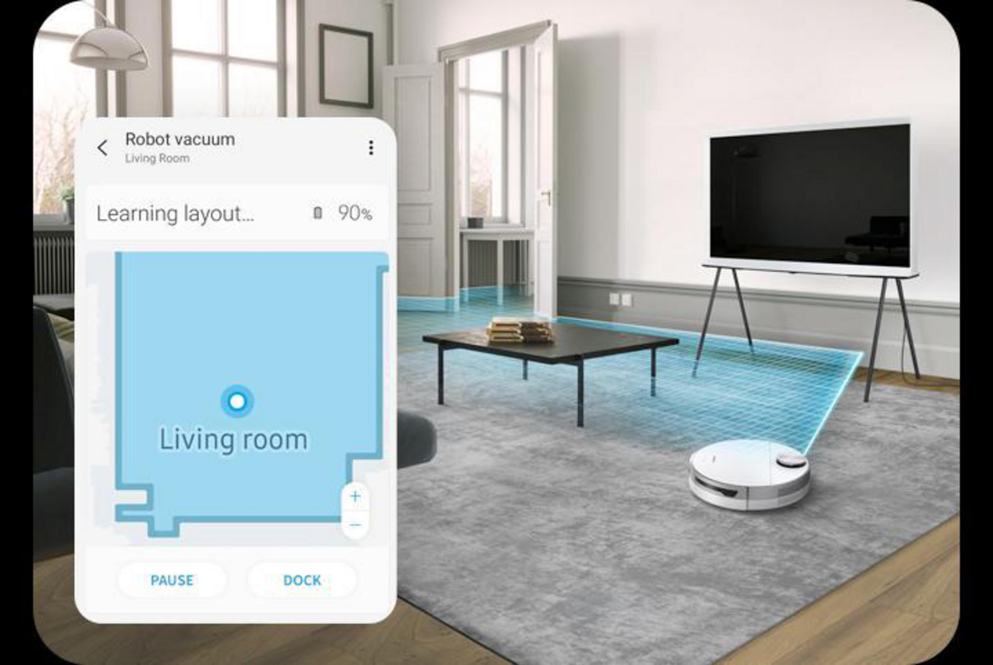 Telefon wyświetlający mapę robota sprzątającego w salonie, z robotem w pobliżu.