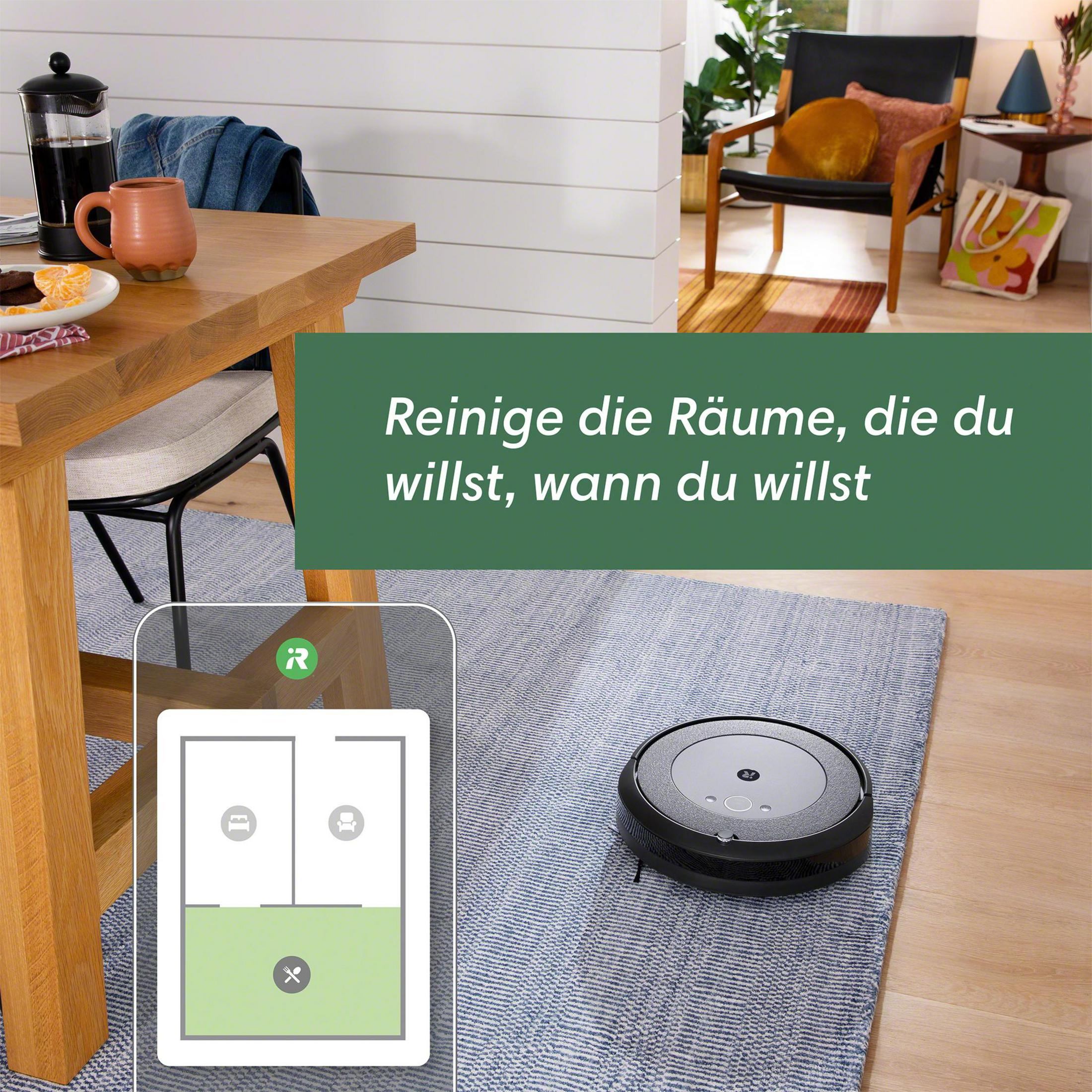 Ein Roboter-Staubsauger auf einem Teppich. Ein Telefonbildschirm zeigt ein Raumlayout.