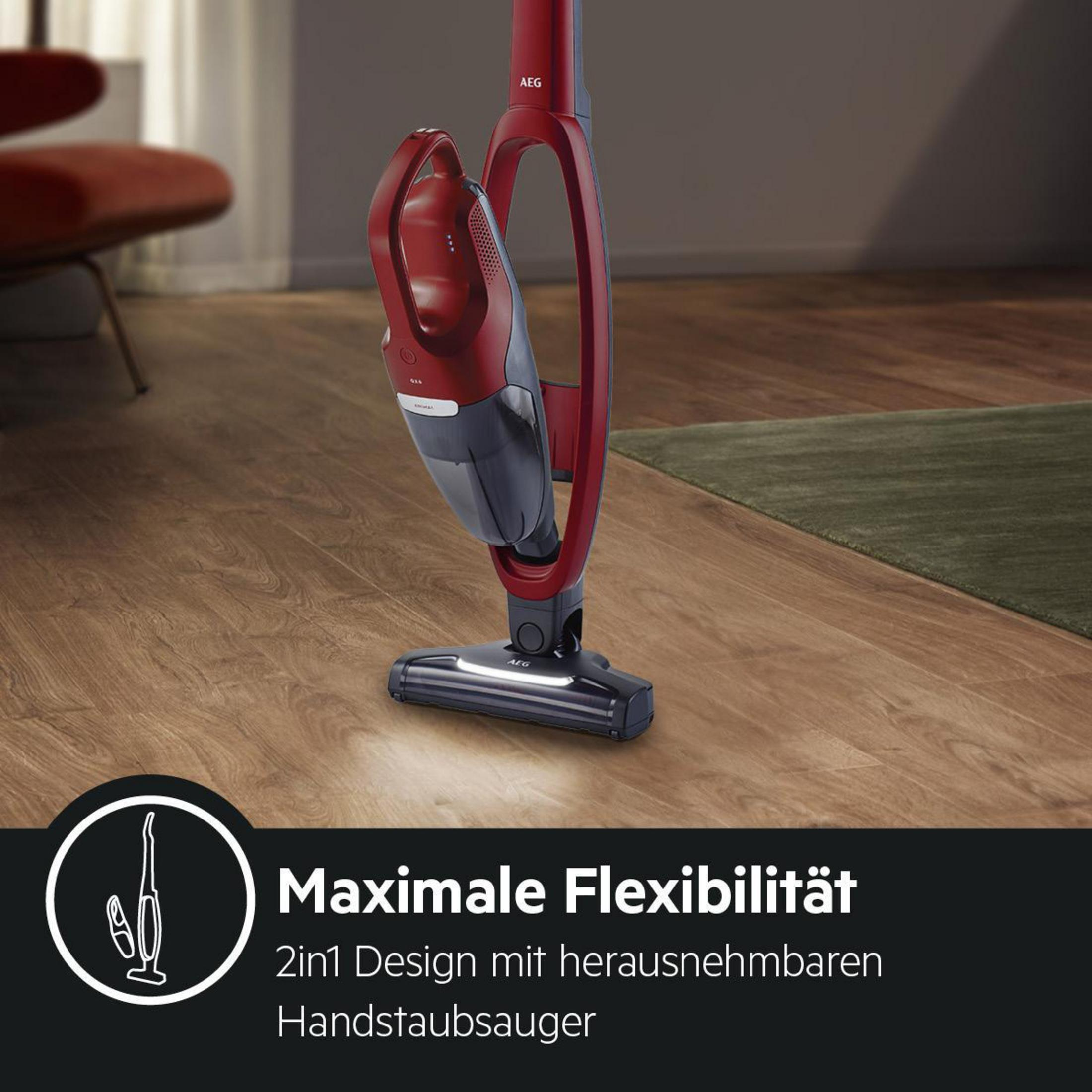 Roter und schwarzer AEG Staubsauger auf einem Holzboden. Der Staubsauger ist in Betrieb.