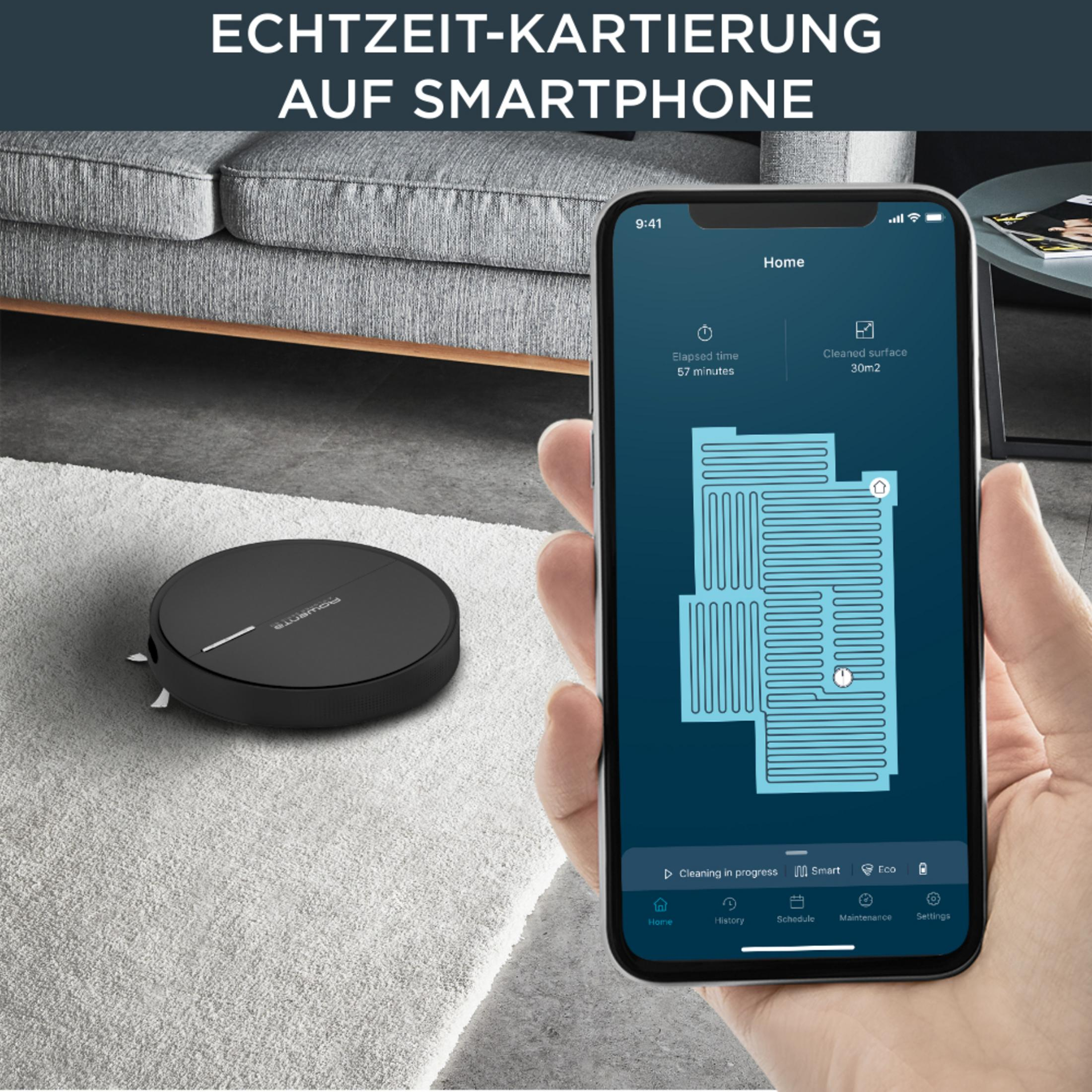 Robot sprzątający na dywanie, telefon z mapą sprzątania i tekstem po niemiecku.