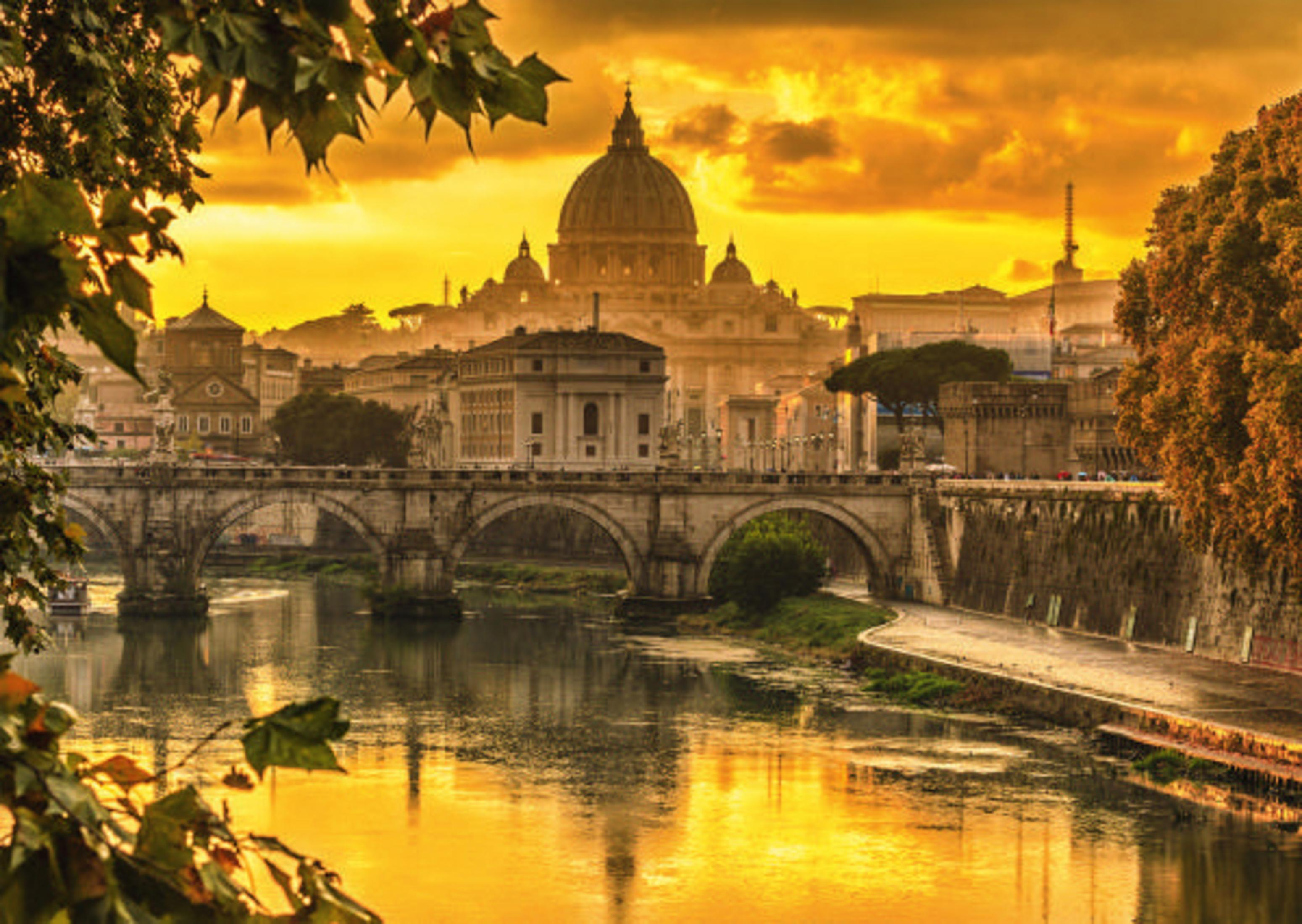 Rom bei Sonnenuntergang. Der Tiber fließt an Gebäuden und einer Brücke vorbei. Goldener Himmel.