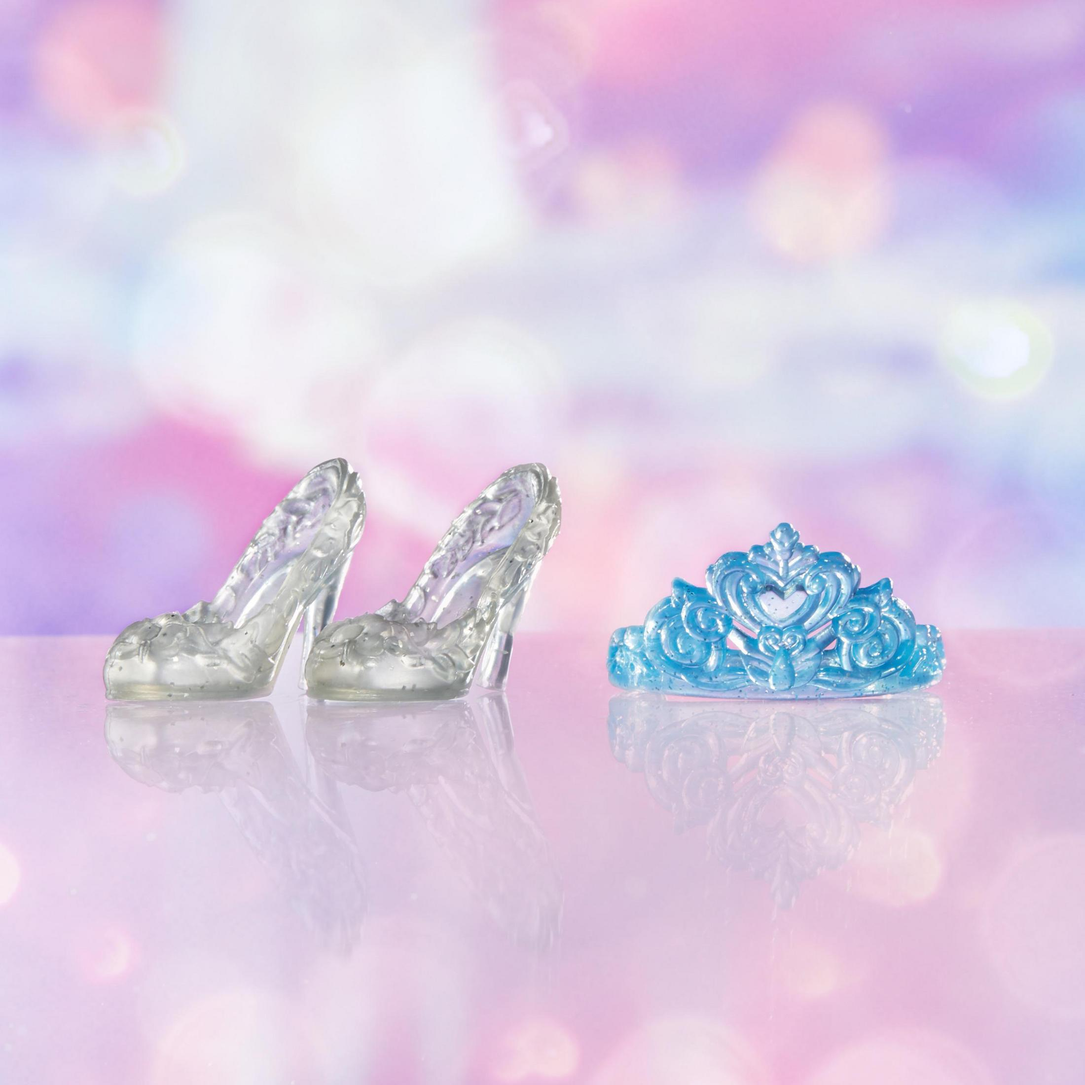 Zapatos de tacón transparentes y una tiara azul. Fondo rosa con efecto bokeh.