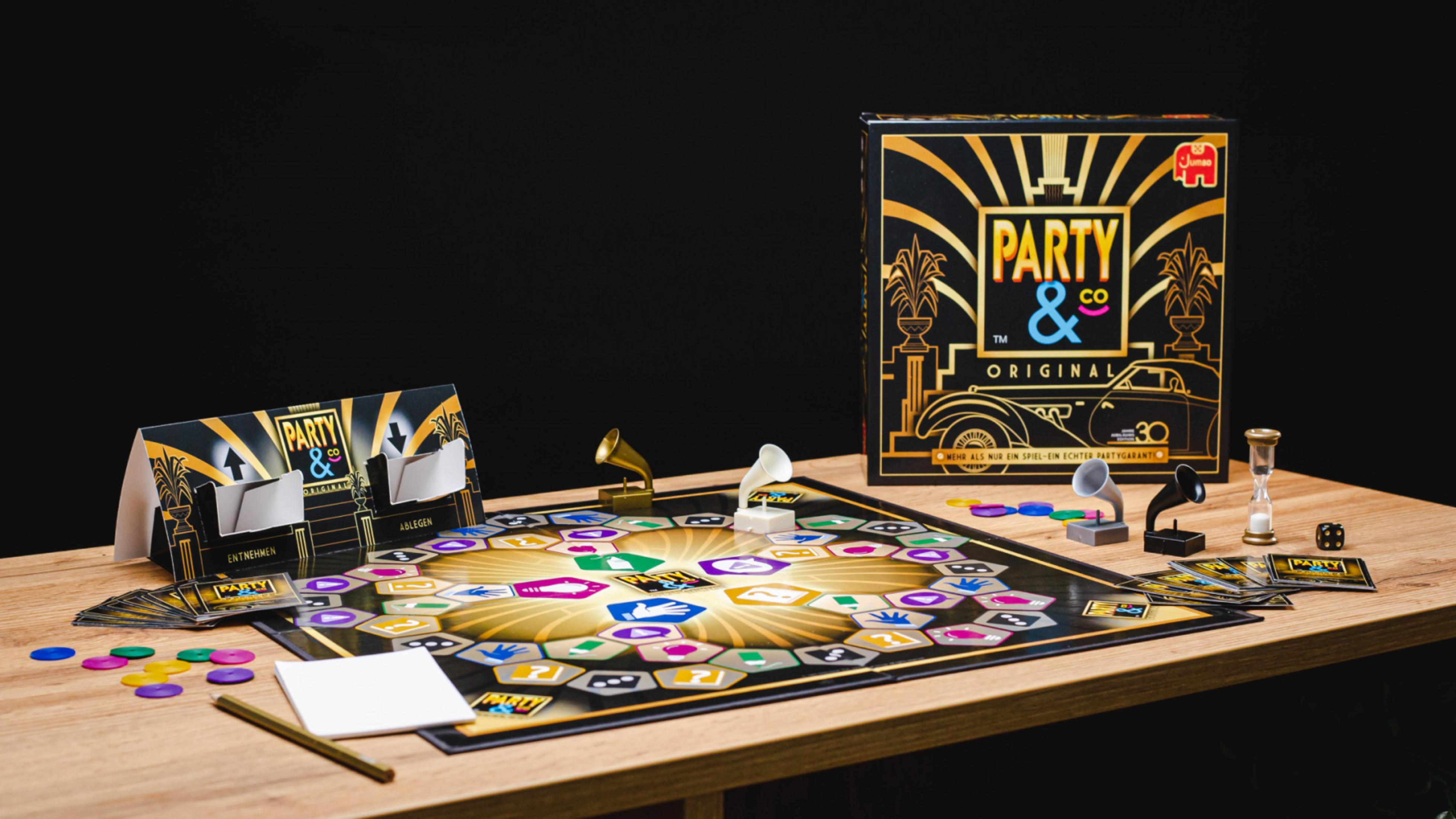 Ein Brettspielkarton steht auf einem Tisch mit Spielsteinen und Karten. Ein schwarzer Hintergrund.