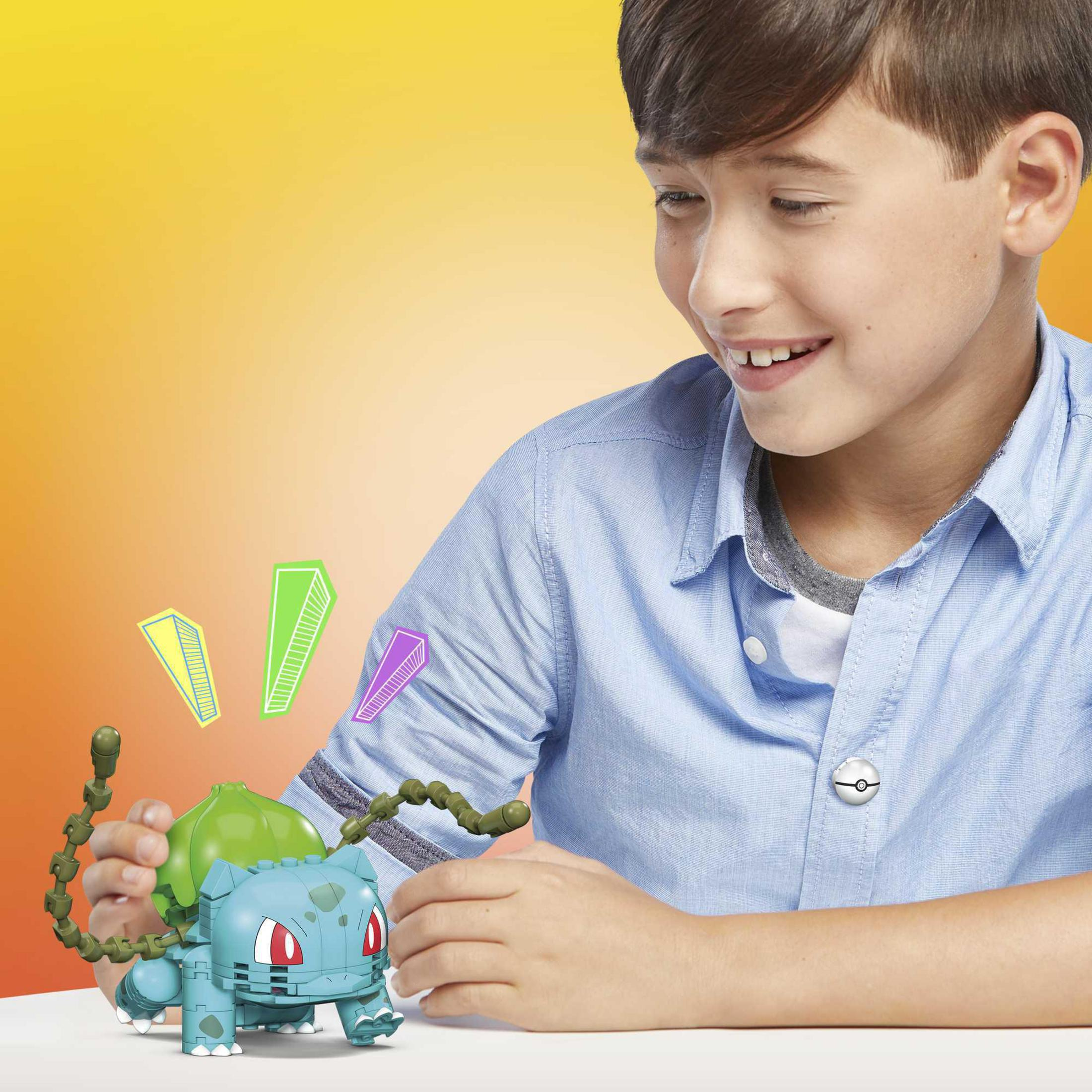 Junge lächelt über ein Pokémon-Spielzeug. Spielzeug ist blau und grün. Bunte Formen schweben darüber.