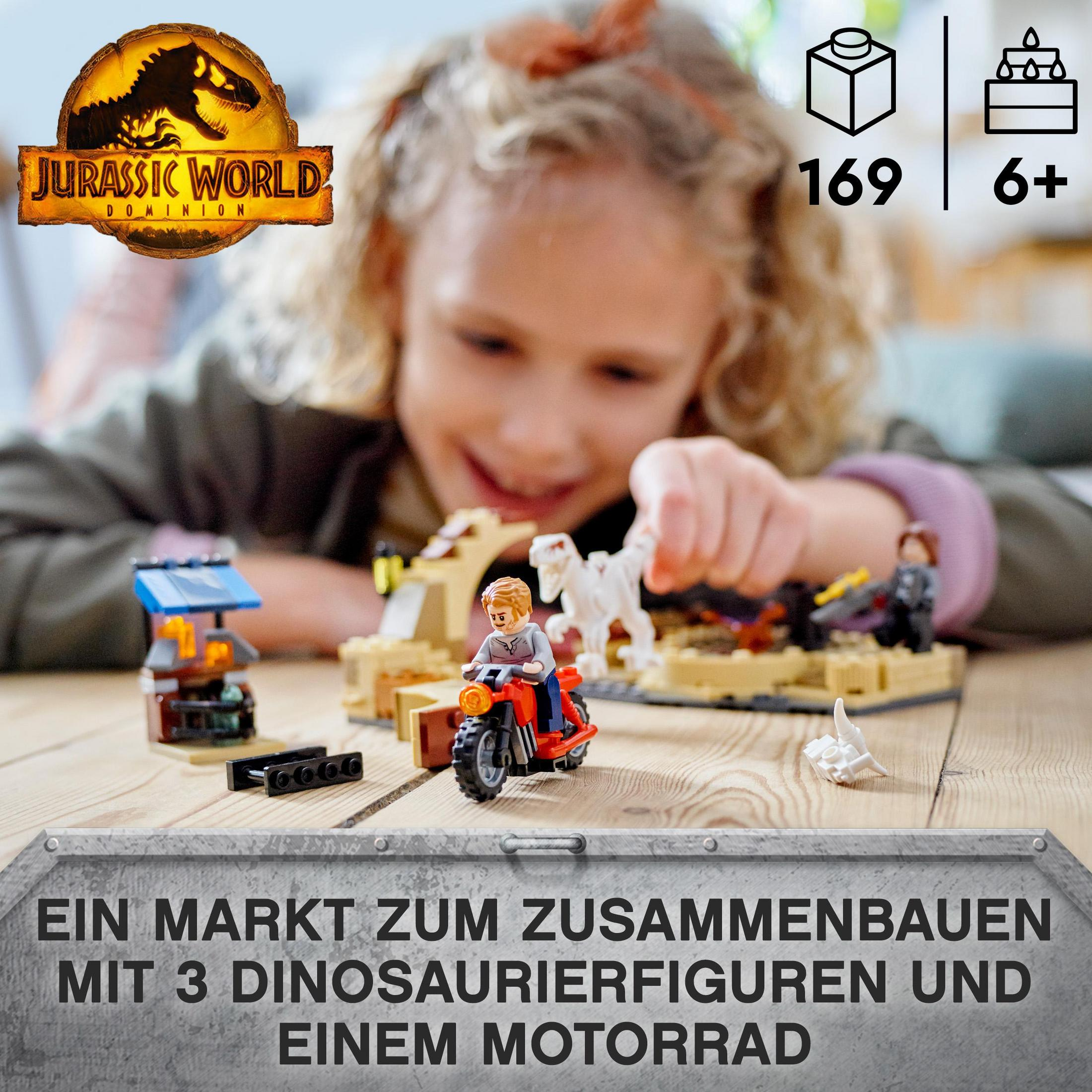Fille jouant avec un ensemble Lego Jurassic World, avec une moto et des figurines de dinosaures.