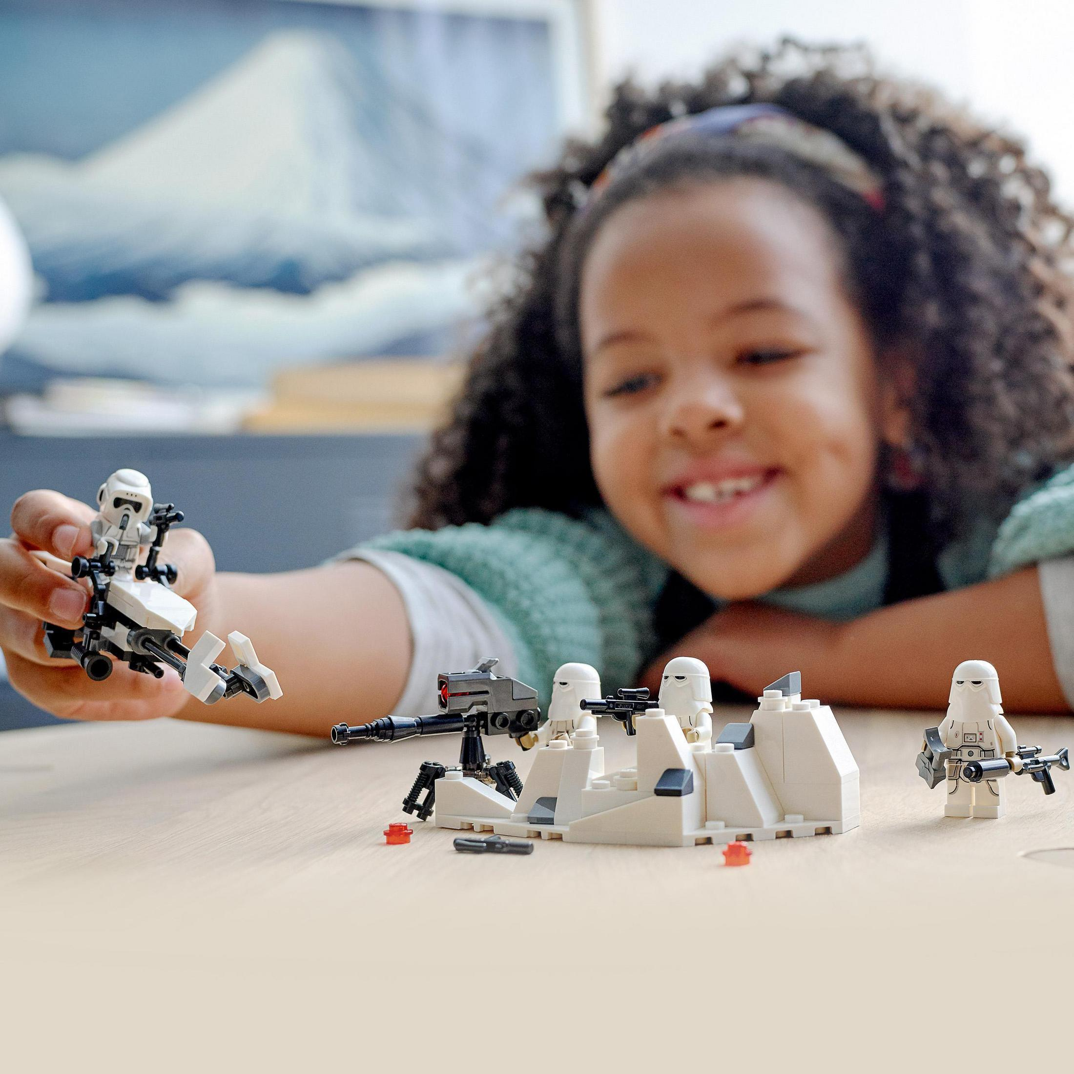 Mädchen spielt mit Star Wars Lego-Figuren auf einem Tisch.