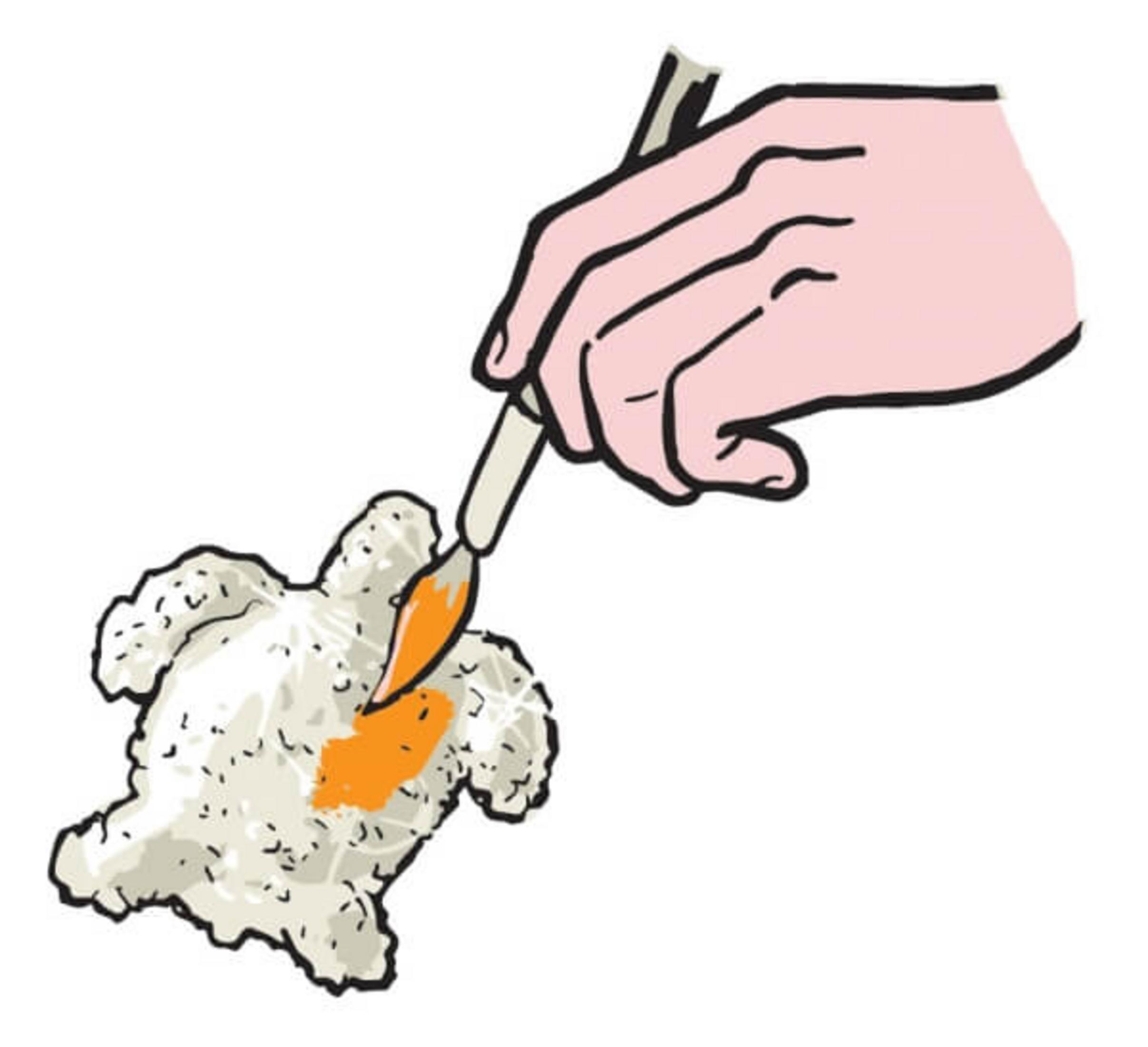 Eine Hand bemalt ein weißes, tropfenförmiges Objekt mit einem Pinsel orange.