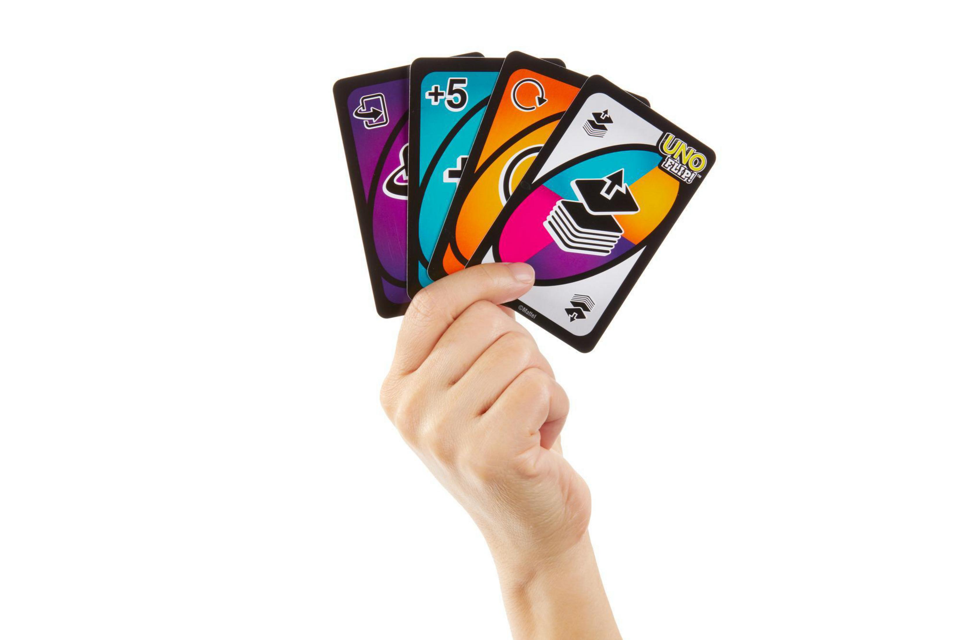 Une main tenant quatre cartes Uno. Les cartes ont différentes couleurs et symboles.
