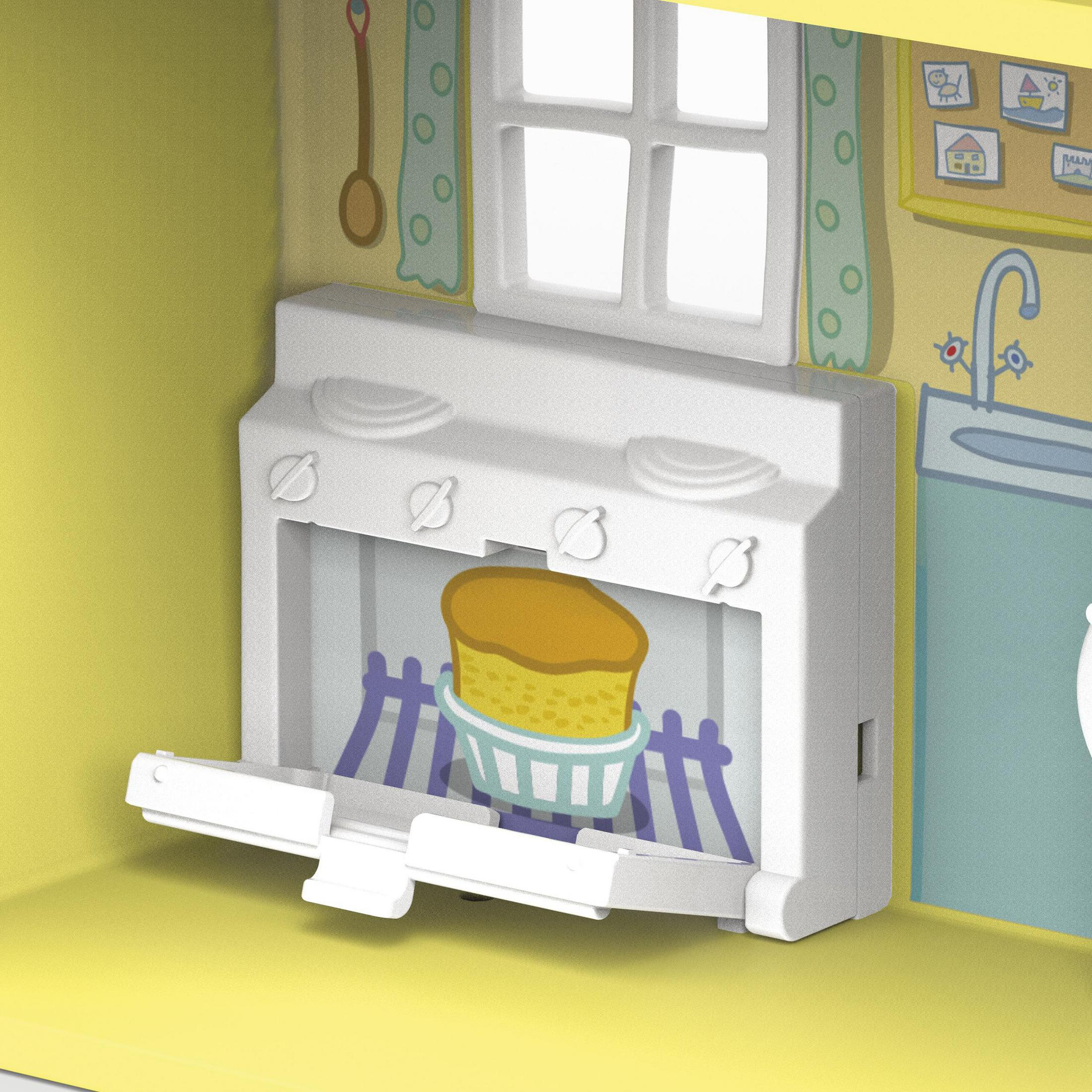 Dentro de una cocina de juguete con un pastel en el horno y una ventana arriba.