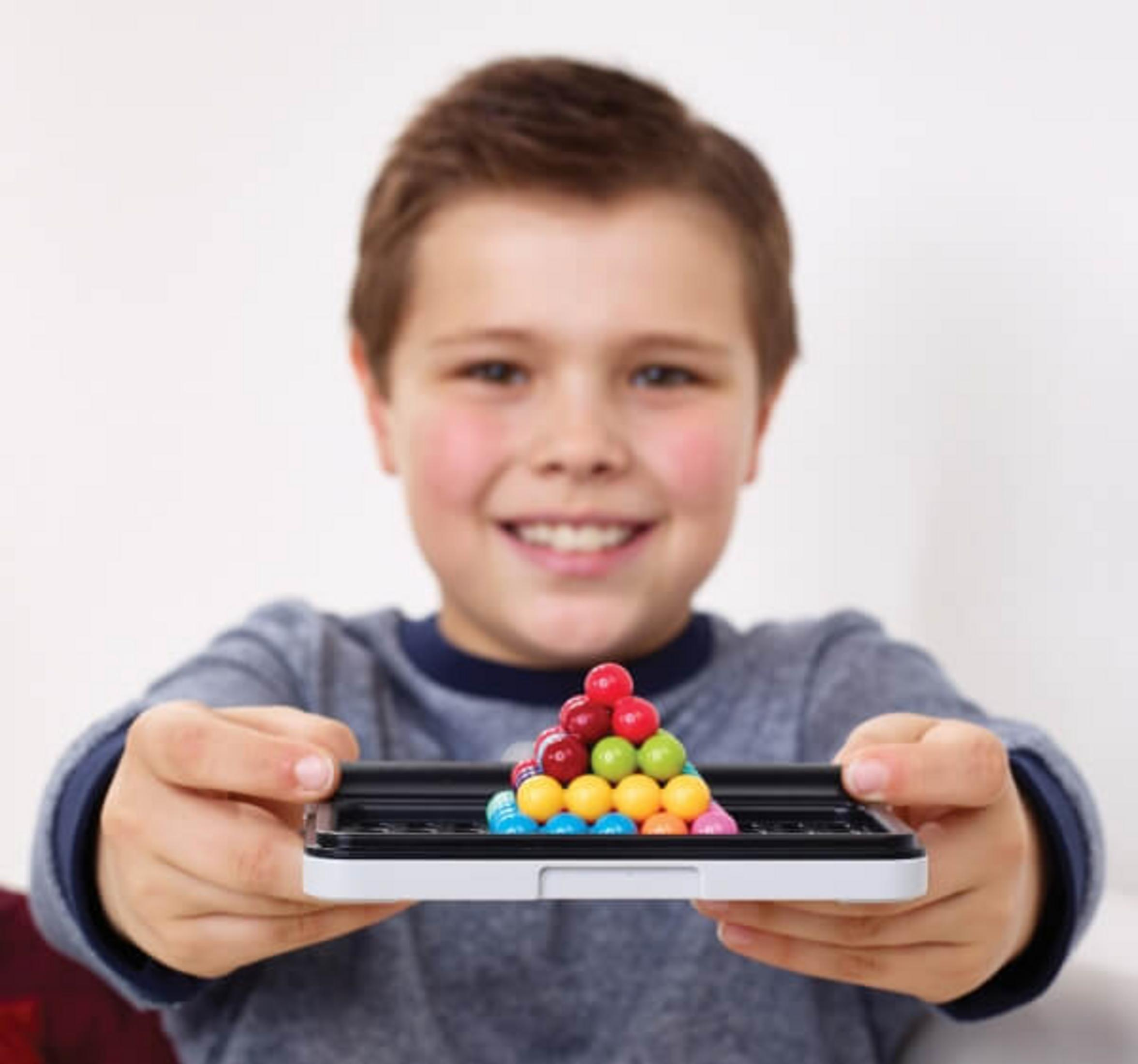 Un ragazzino che tiene un tabellone nero con palline colorate disposte a forma di piramide.