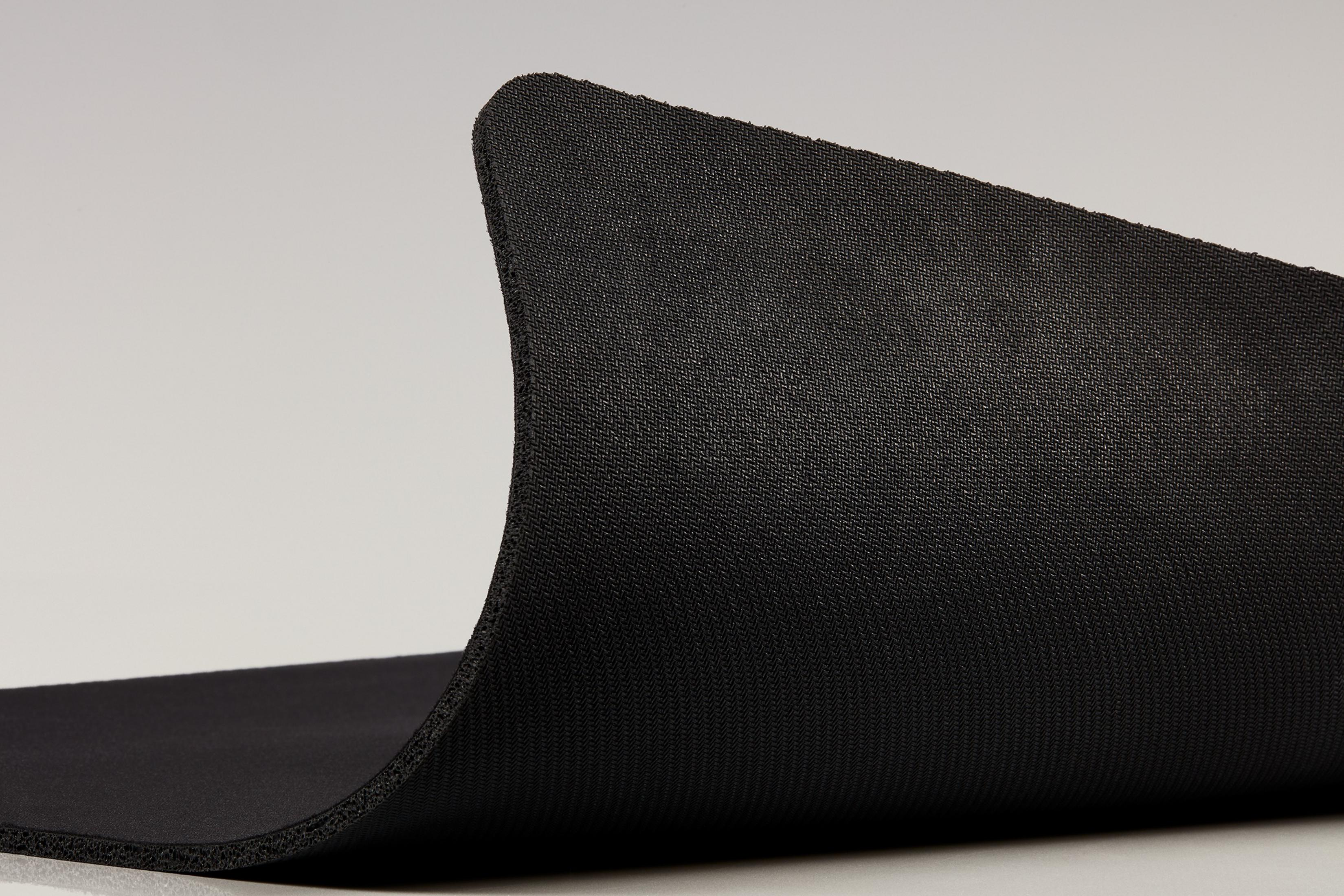 Zbliżenie czarnego, teksturowanego materiału piankowego. Pianka jest wygięta do góry.