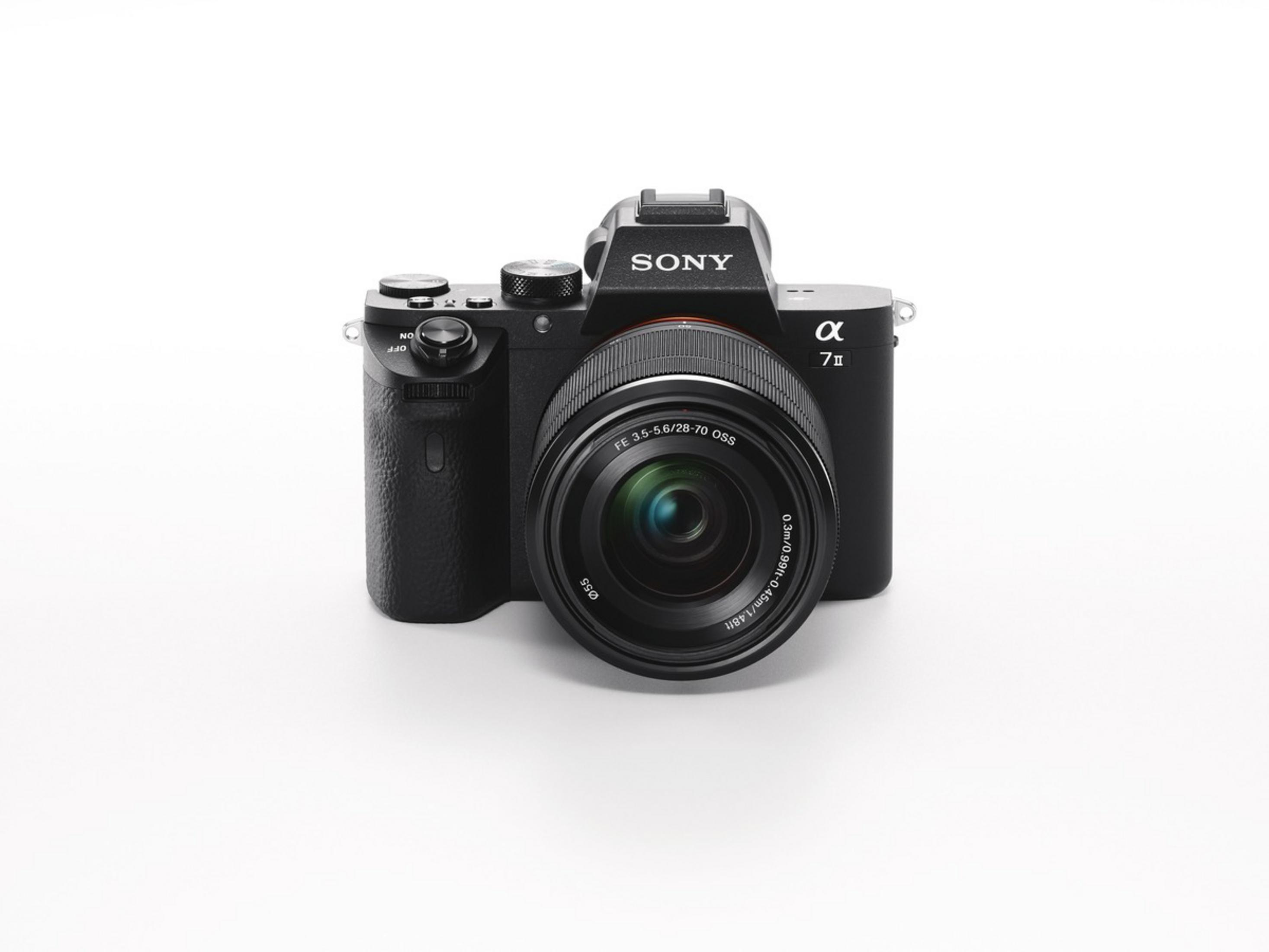 Una cámara Sony Alpha 7 II negra sobre una superficie blanca, lente hacia el espectador.