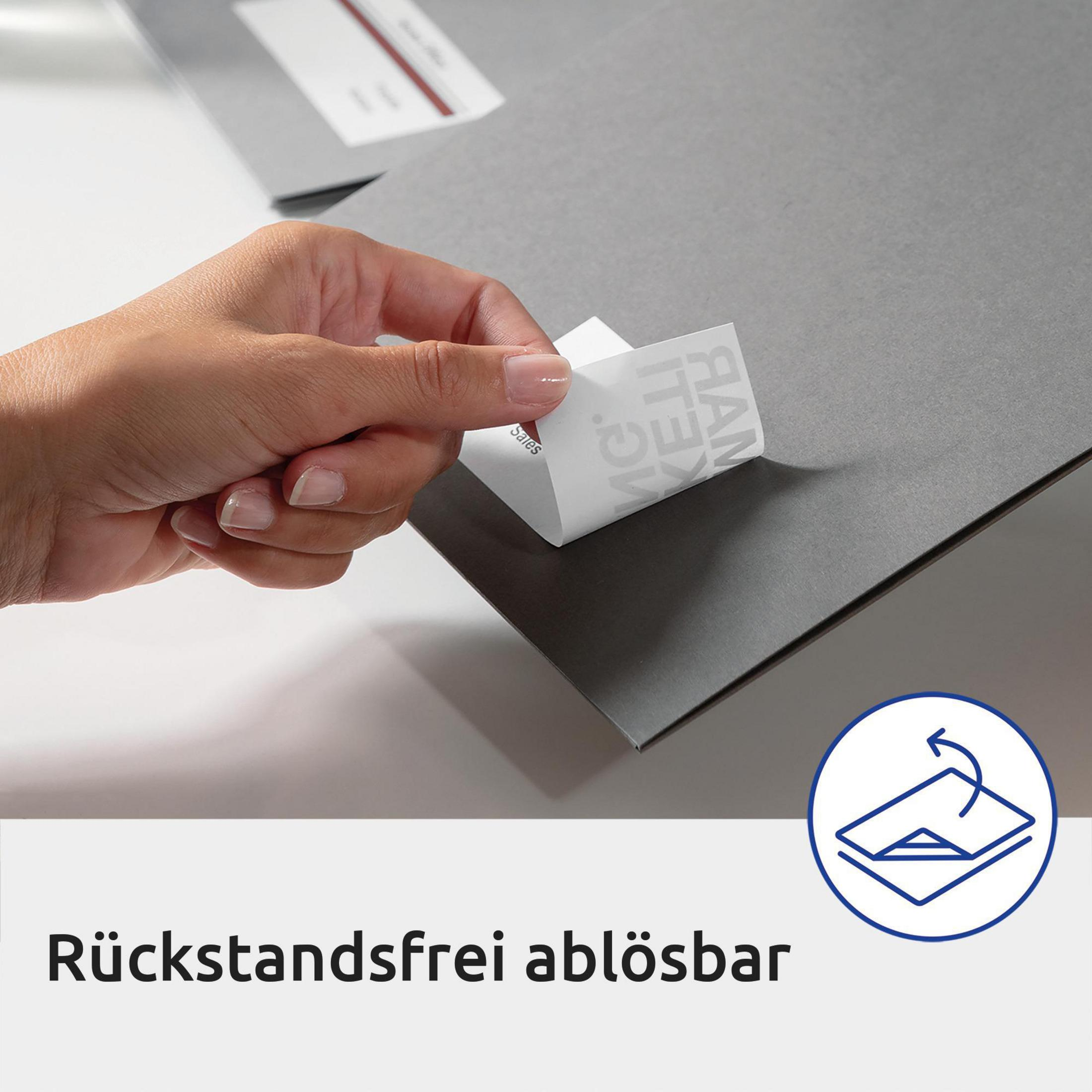Eine Hand, die einen weißen Aufkleber von einem grauen Papier abzieht, mit Text auf Deutsch.