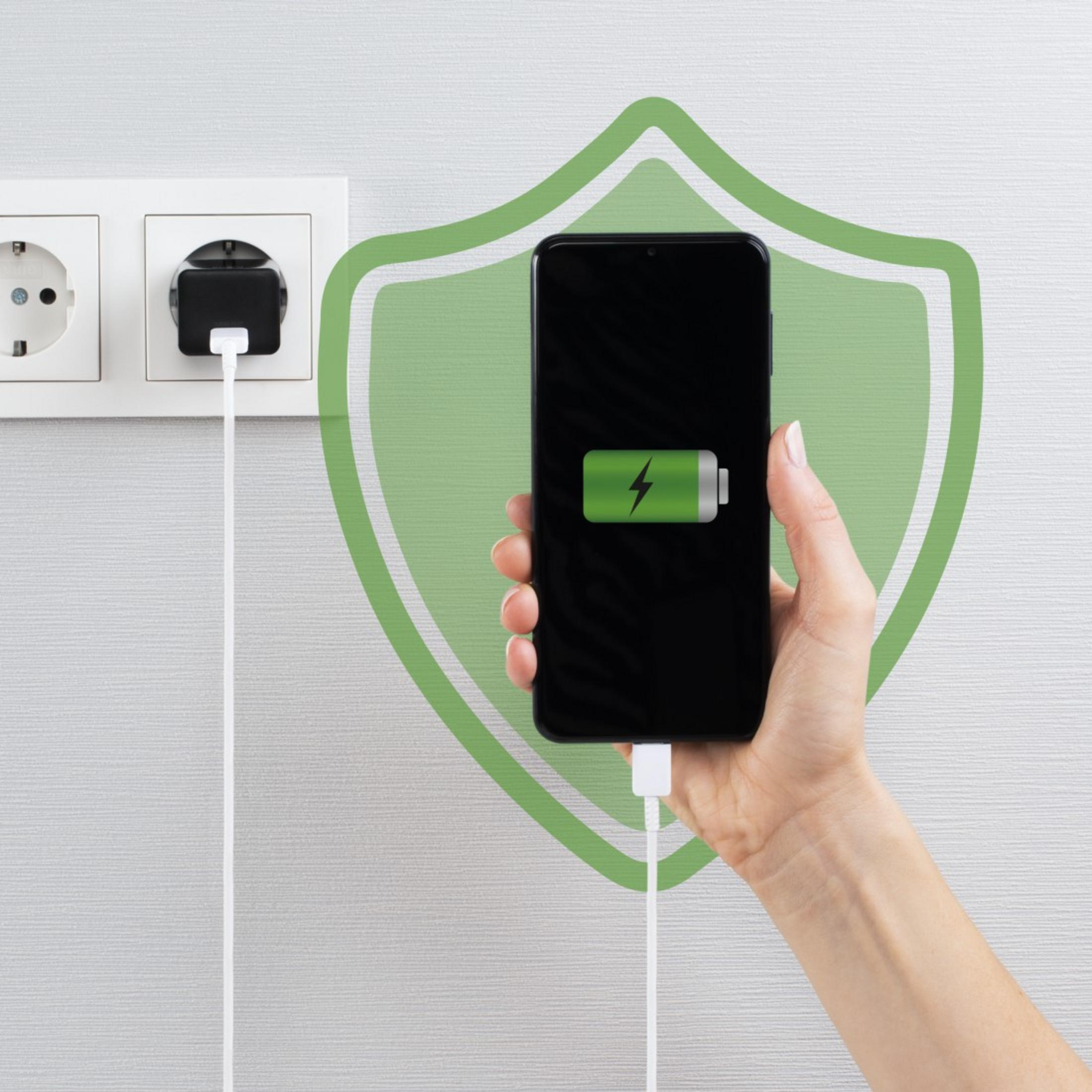 Dłoń trzymająca ładujący się telefon. Zielona ikona tarczy jest nałożona.