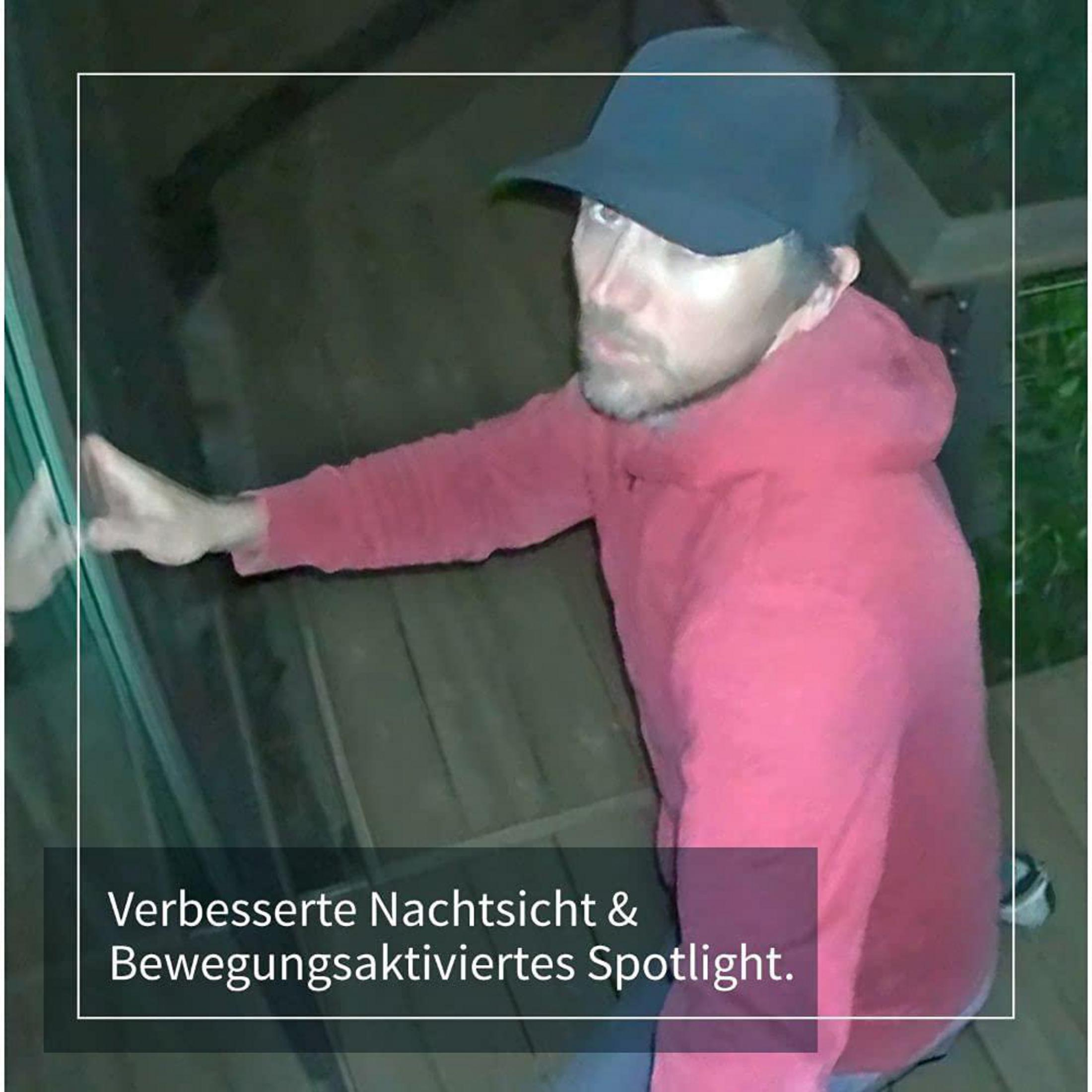 Mann mit Mütze und rotem Kapuzenpullover blickt in eine Kamera. Text: Verbesserte Nachtsicht & Spotlight.