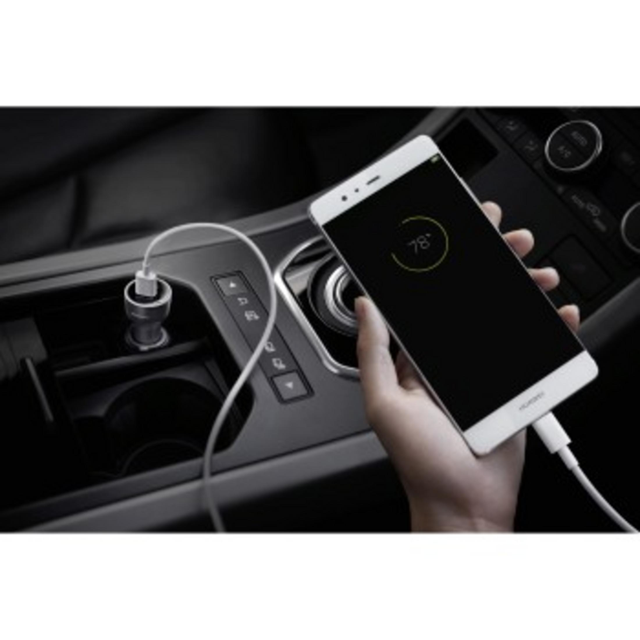 Hand die witte telefoon met oplaaddisplay in auto vasthoudt. USB-kabel aangesloten.