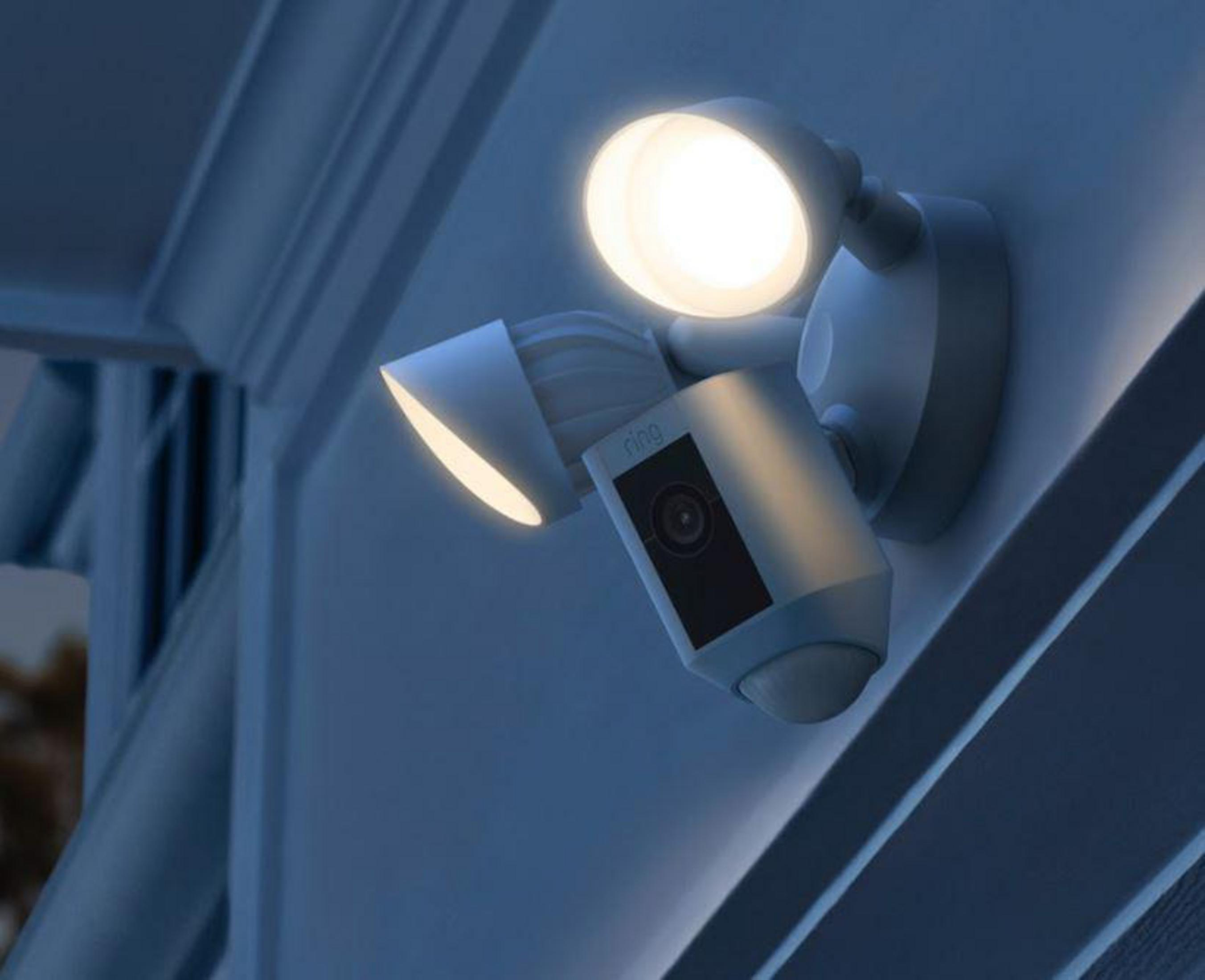 Una luz de seguridad blanca con dos luces brillantes está montada en una pared.