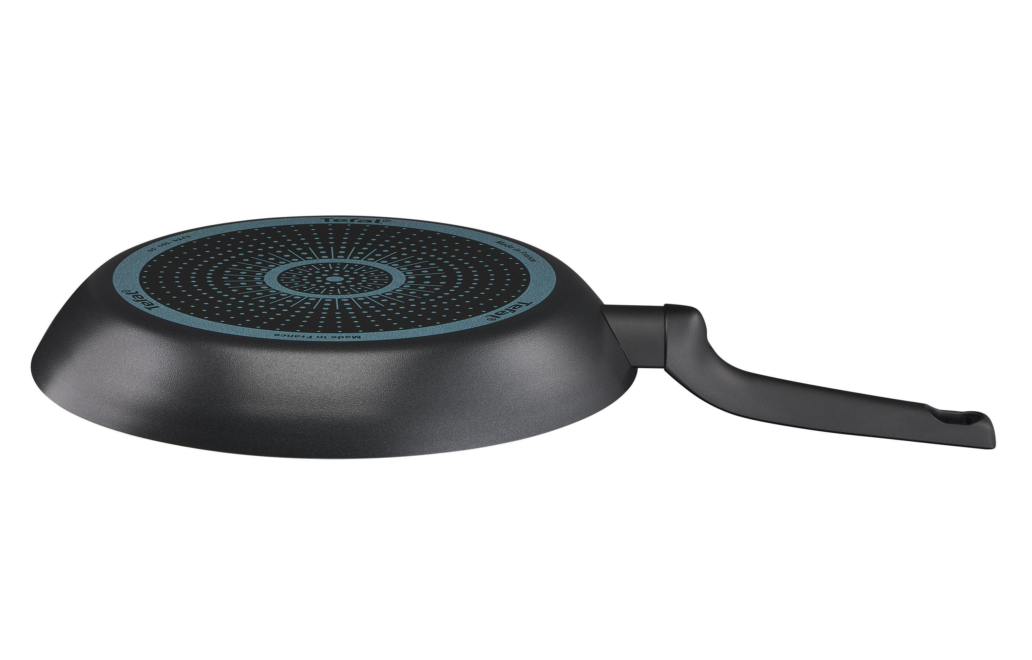 Czarna patelnia z uchwytem, widok od spodu, na białym tle.