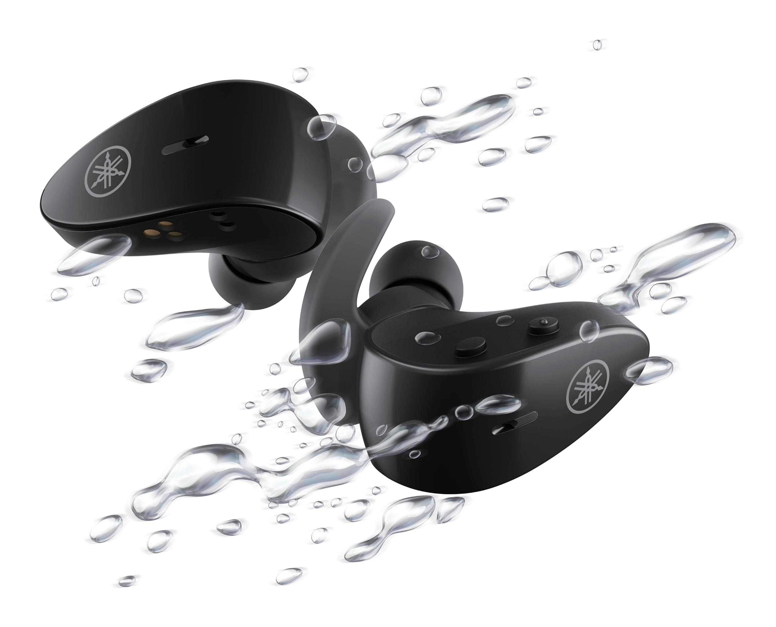 Auriculares Yamaha negros en agua, con gotas de agua alrededor.