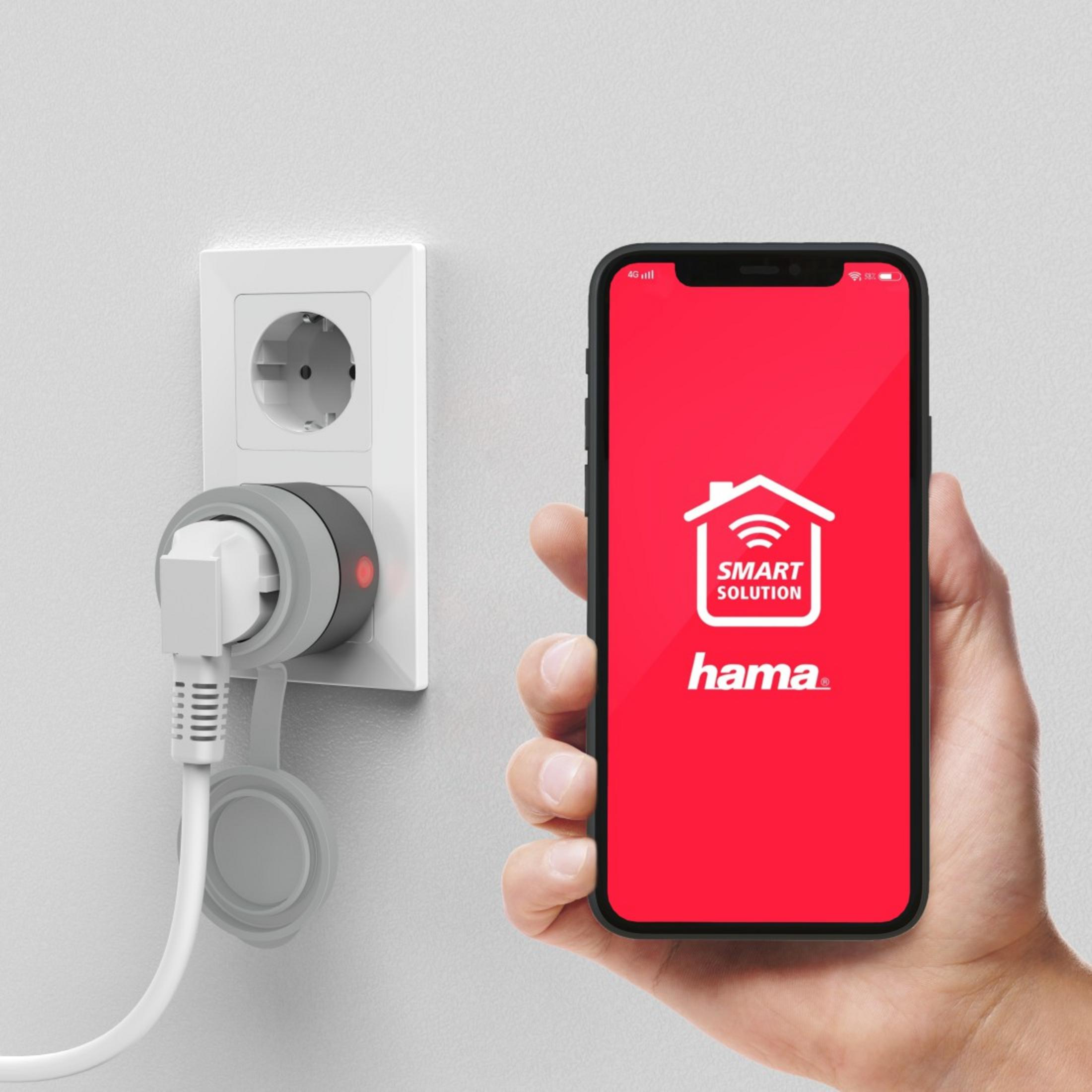 Eine Hand, die ein rotes Telefon hält, das einen rot-weißen Bildschirm zeigt, mit einem Stecker und einer Steckdose.