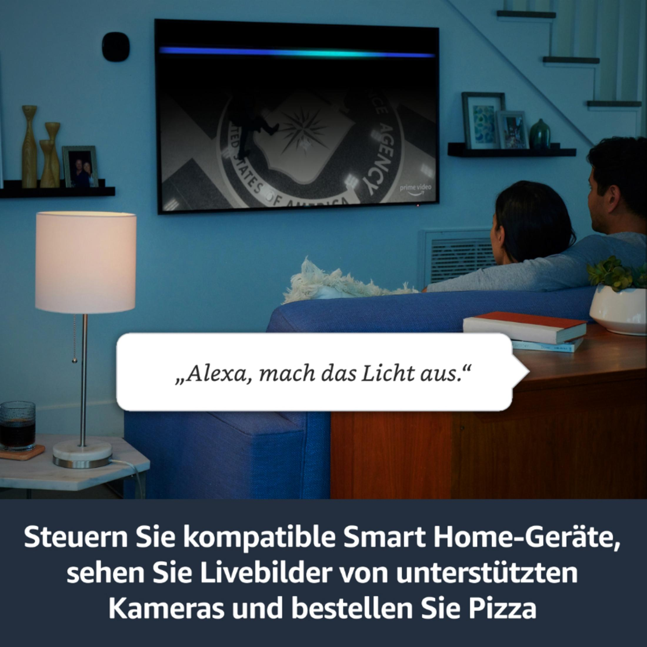 Paar auf Couch schaut TV mit Smart-Home-Anzeige. Links ist eine Lampe.