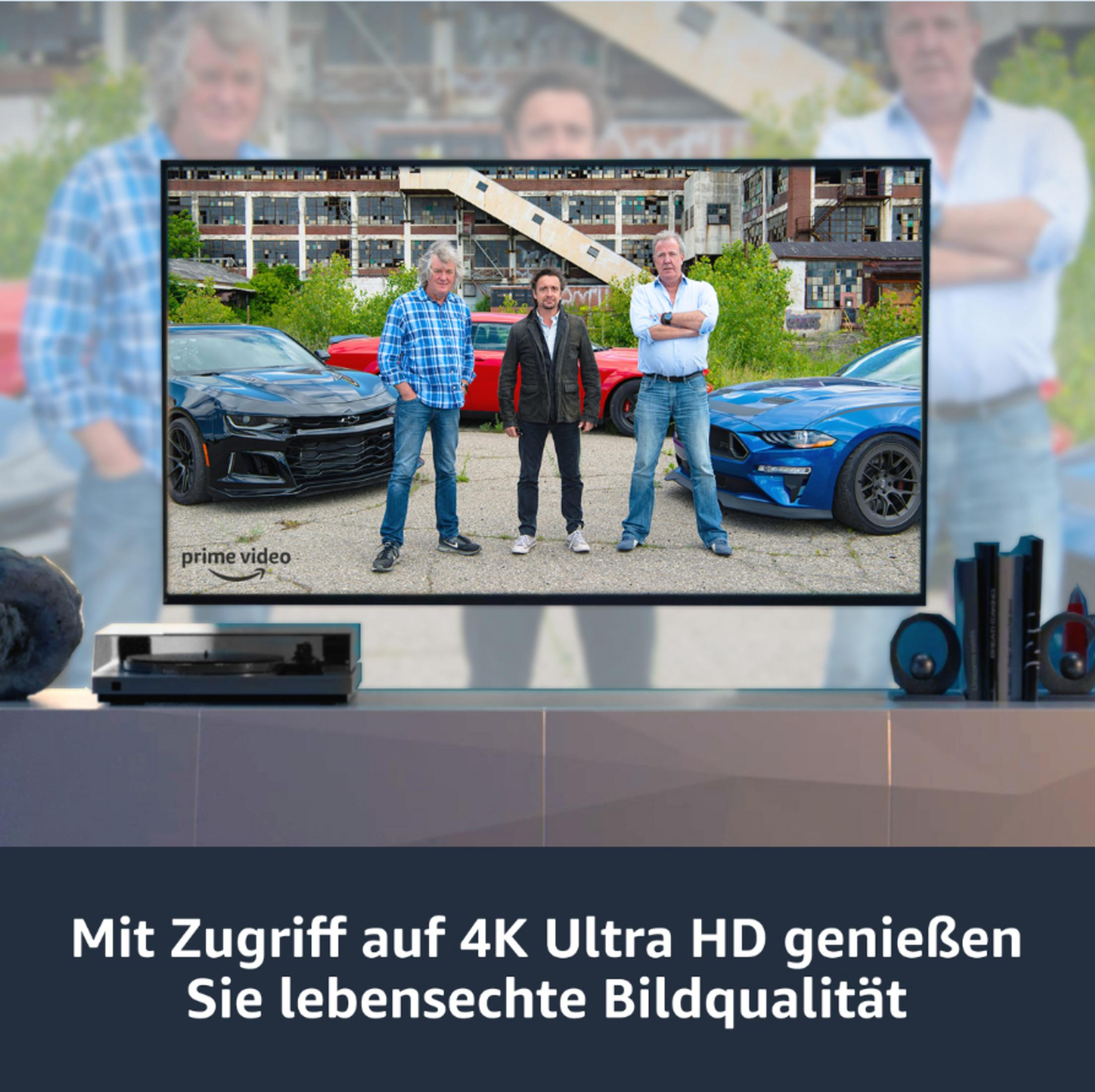 Ein Fernsehbildschirm, der eine Autoshow mit drei Männern zeigt. Text unten: 