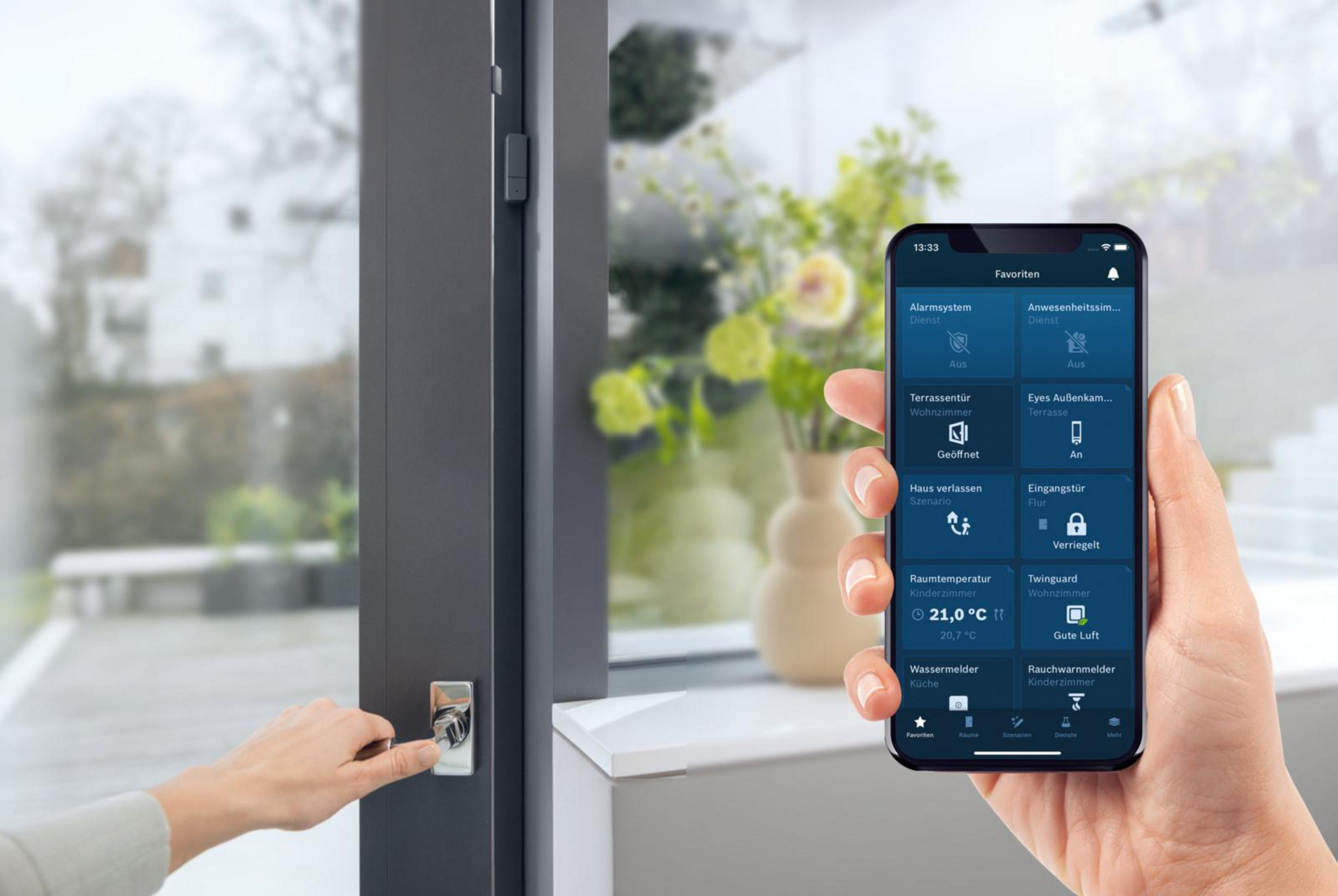 Hand, die ein Telefon hält, das eine Smart-Home-App in der Nähe einer Tür und eines Fensters zeigt.