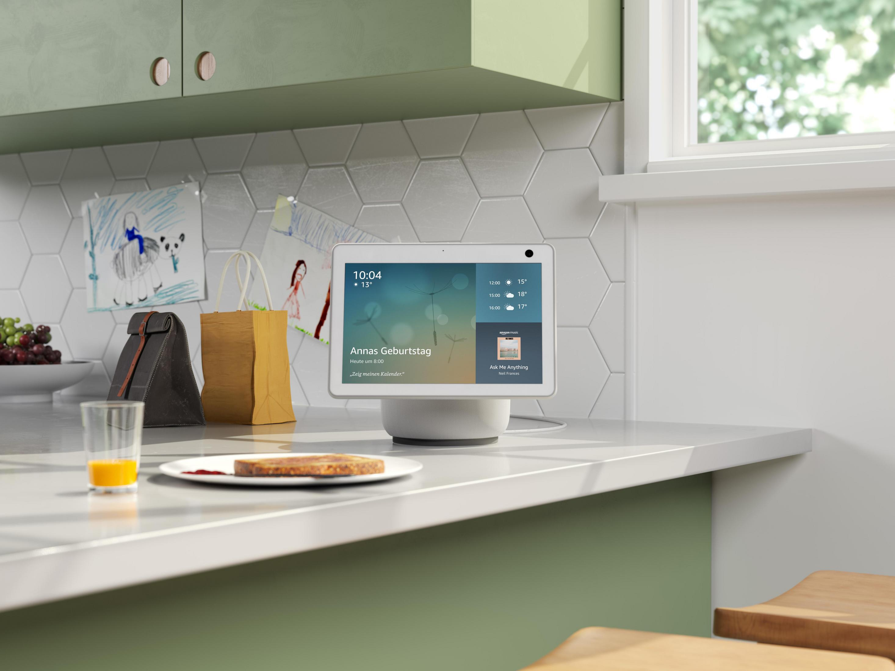 Smart Display auf einer Theke mit Essen und zwei Tüten. Das Display zeigt einen Kalender.