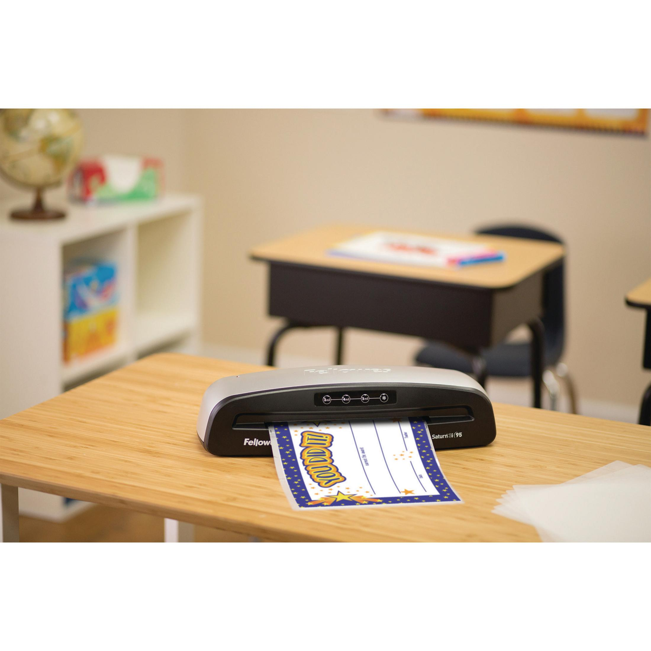 Laminator na drewnianym stole z wychodzącym papierem, w klasie.