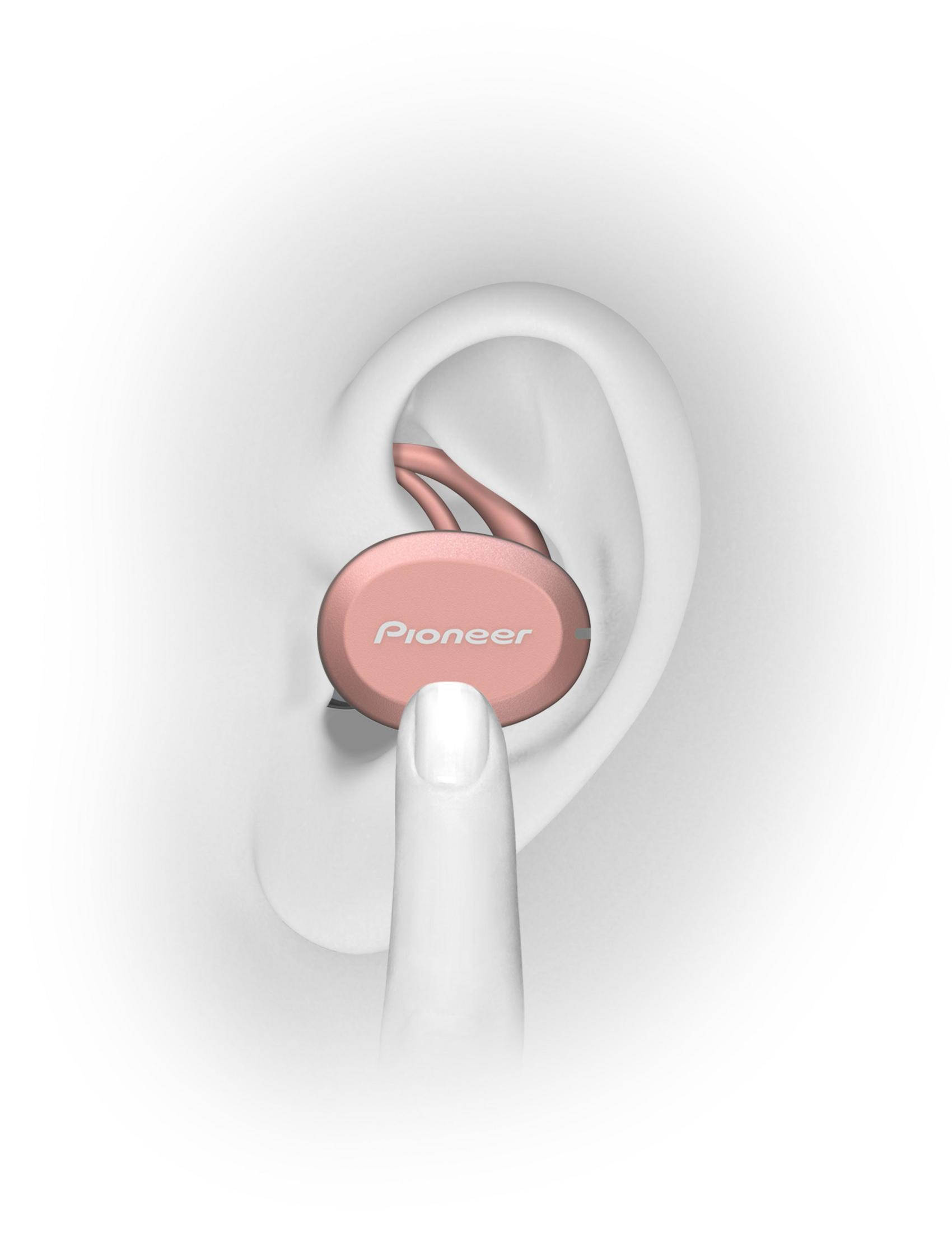 Eine Hand berührt einen rosa Ohrhörer im Ohr. 'Pioneer' ist auf dem Ohrhörer aufgedruckt.