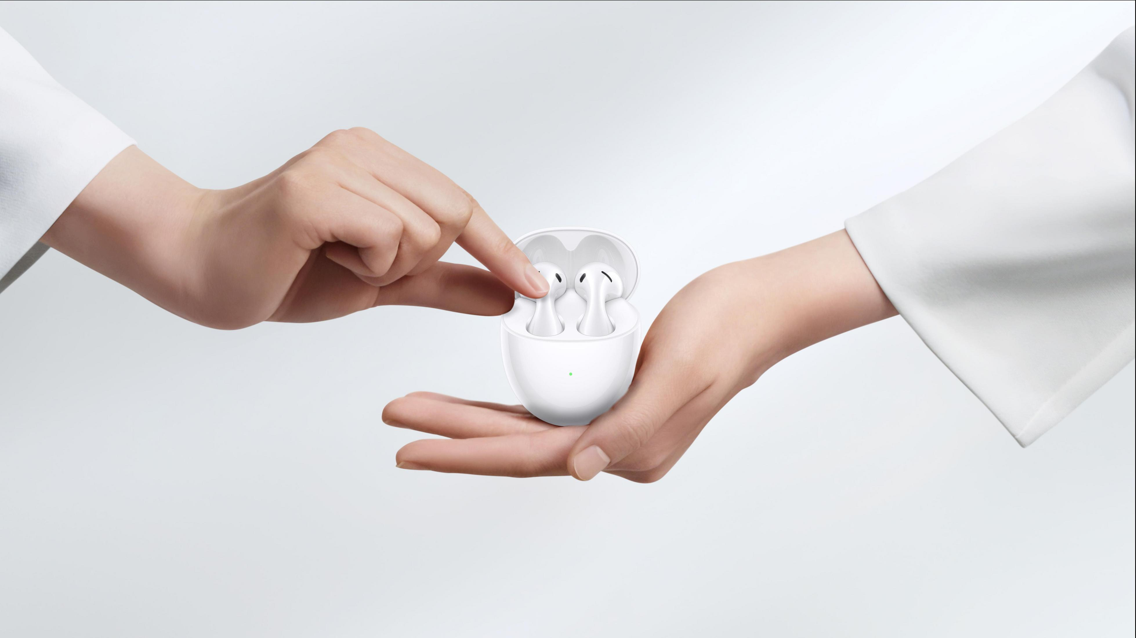 Dłonie dzielące białe etui na słuchawki i słuchawki.
