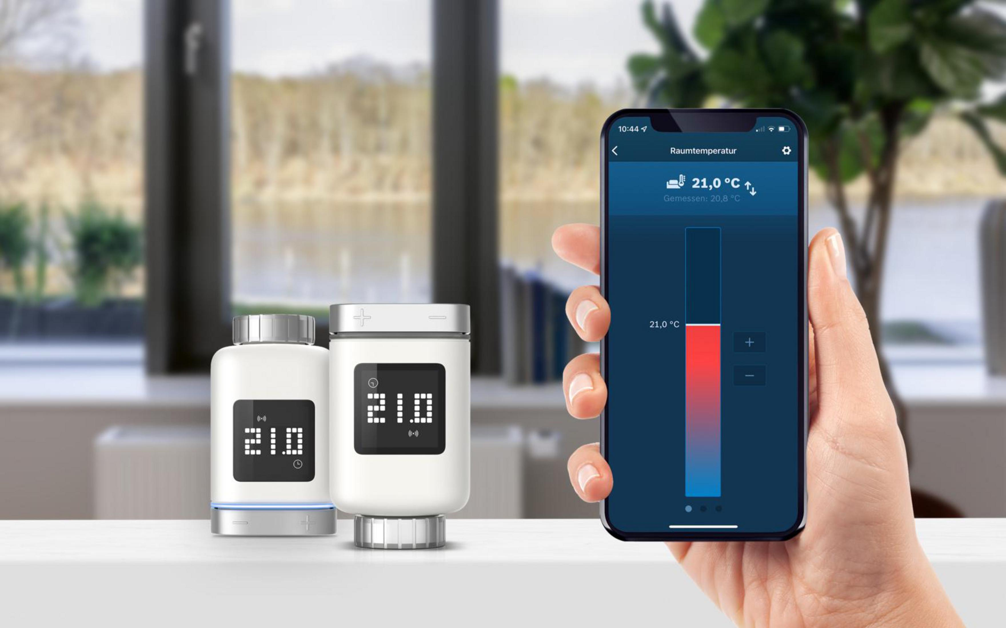 Thermostat, Telefon mit Temperaturanzeige, Fenster und verschwommener Hintergrund.