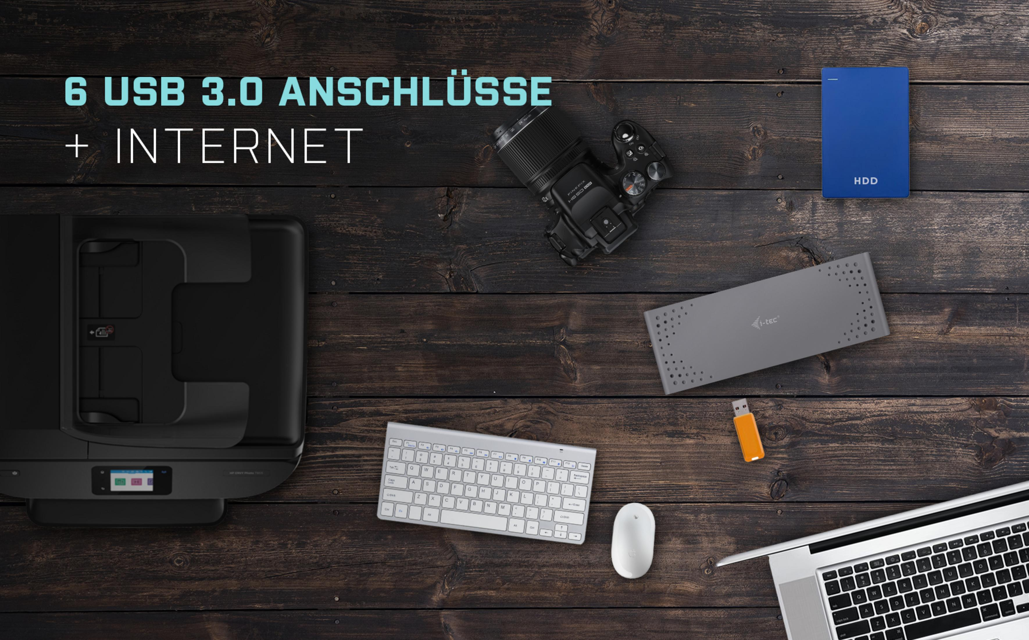Bureau met printer, camera, toetsenbord, harde schijf en laptop.