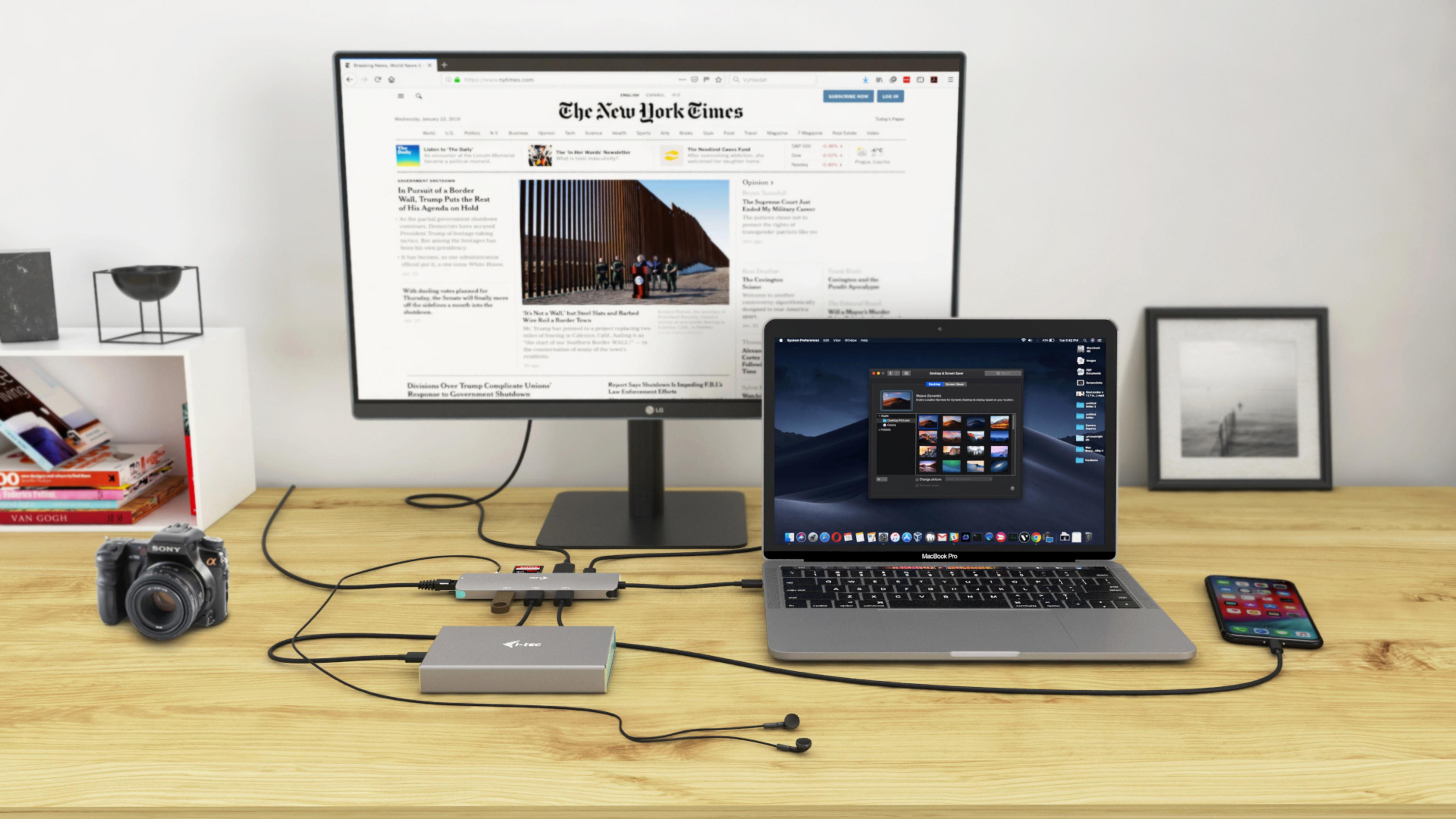Ein Schreibtisch mit Computer, Monitor, Kamera, Telefon und anderem Zubehör. Auf dem Monitor wird ein Bild angezeigt.