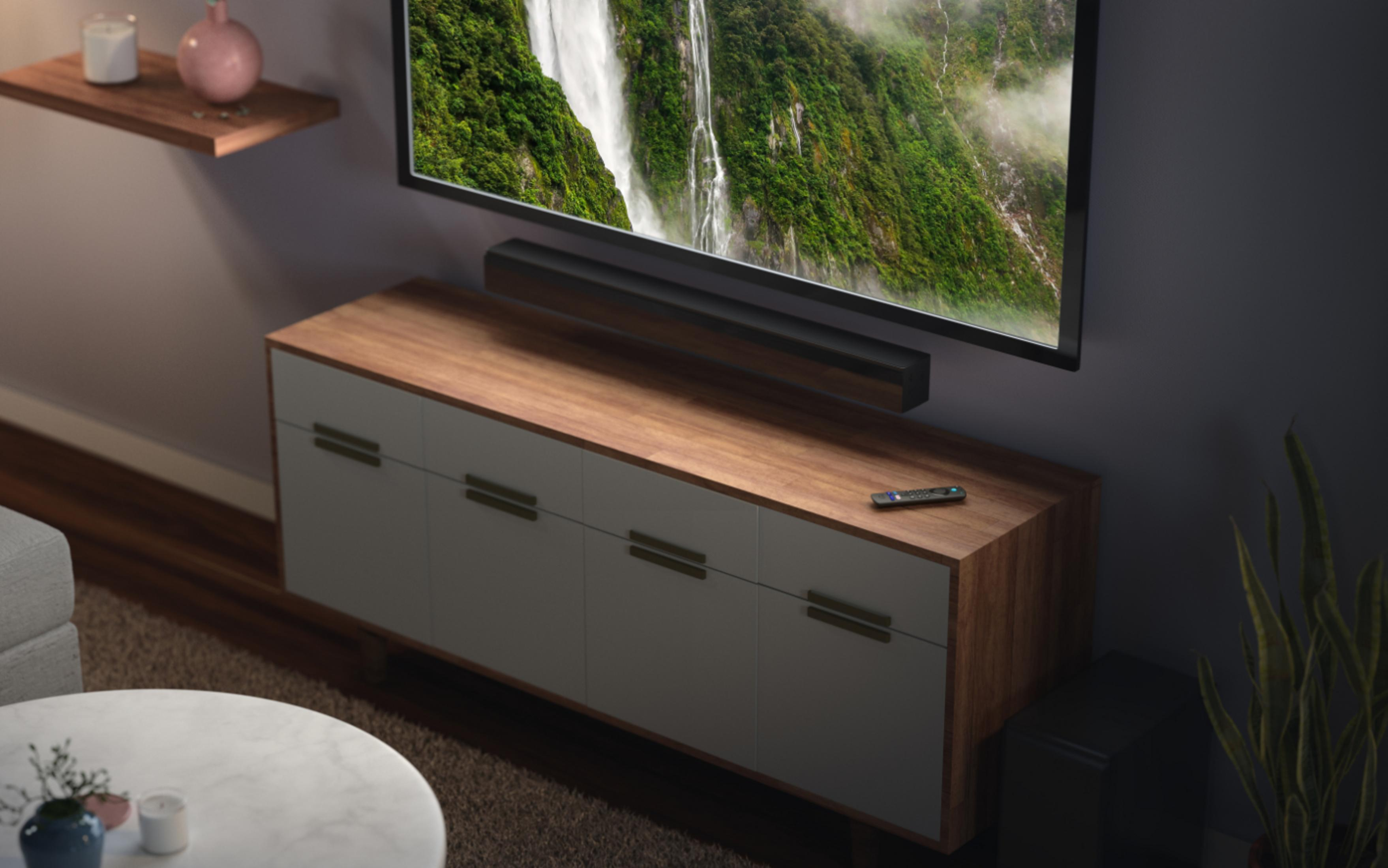 Wohnzimmer-Setup mit TV, Soundbar und Schrank, mit Fernbedienung.
