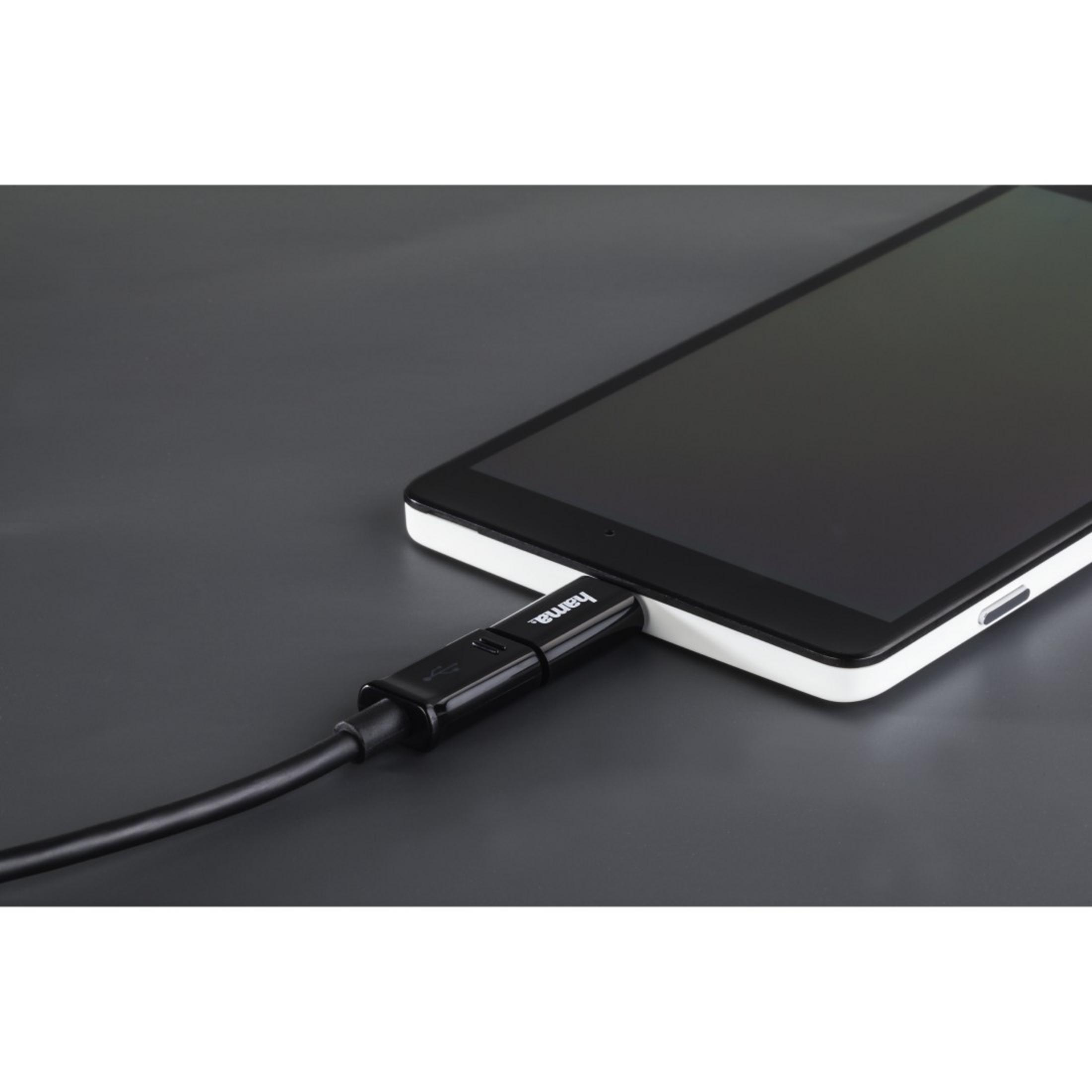 Czarny kabel podłączony do tabletu. Czarny stół w tle.